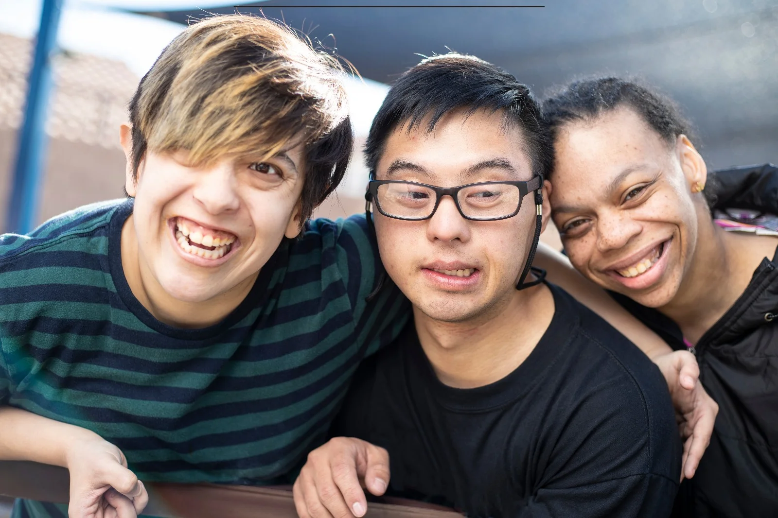 Three smiling friends enjoying companionship and dignity in an adult family home community