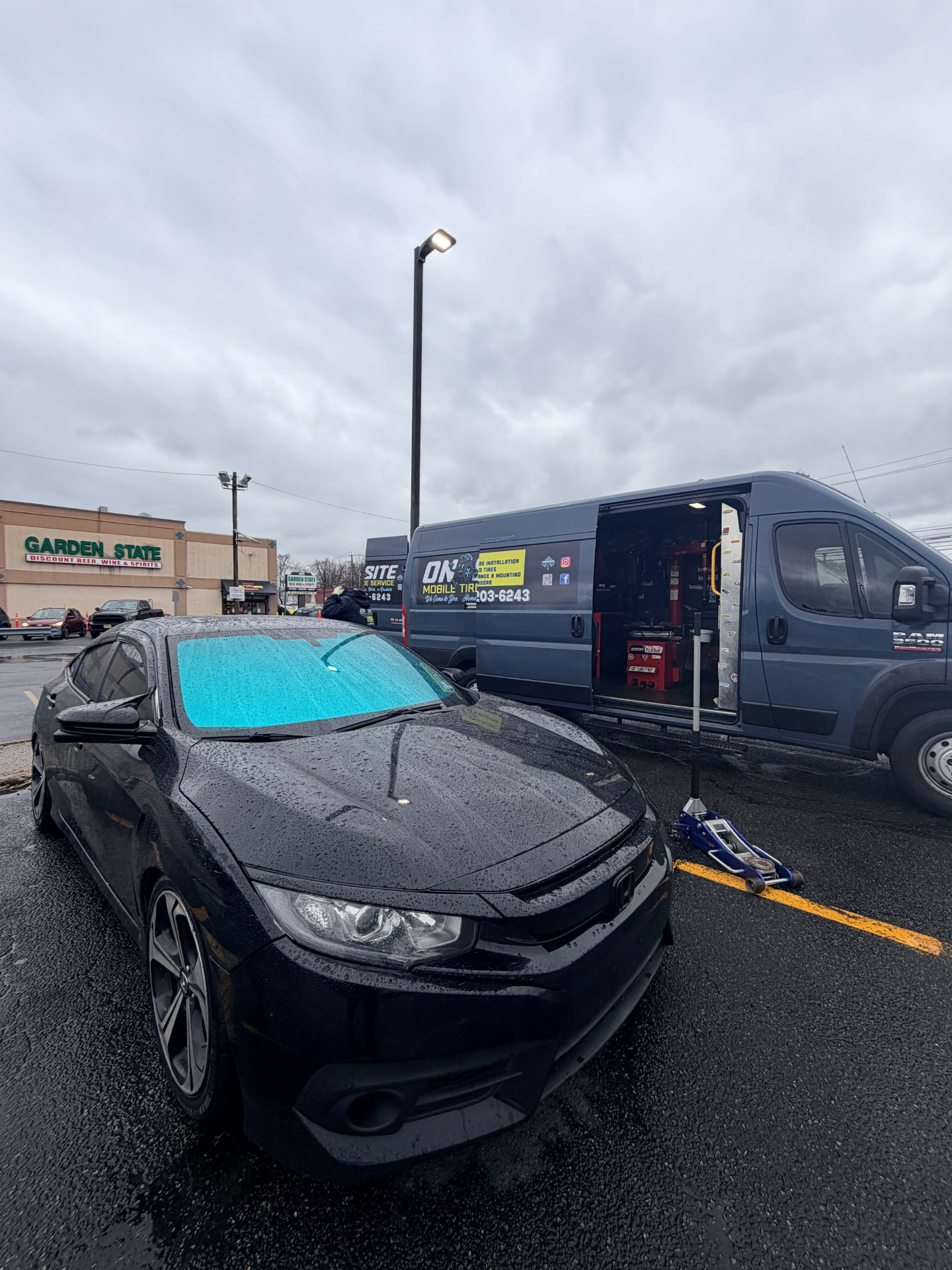 Honda Civic getting mobile tire service in a parking lot - On Site Mobile Tire Service