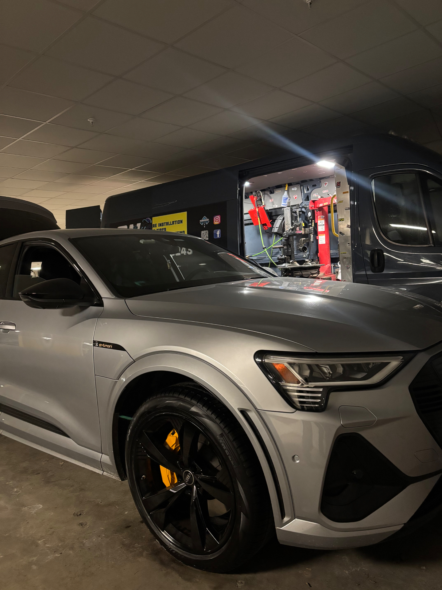 Audi e-tron getting mobile tire service in an indoor garage - On Site Mobile Tire Service