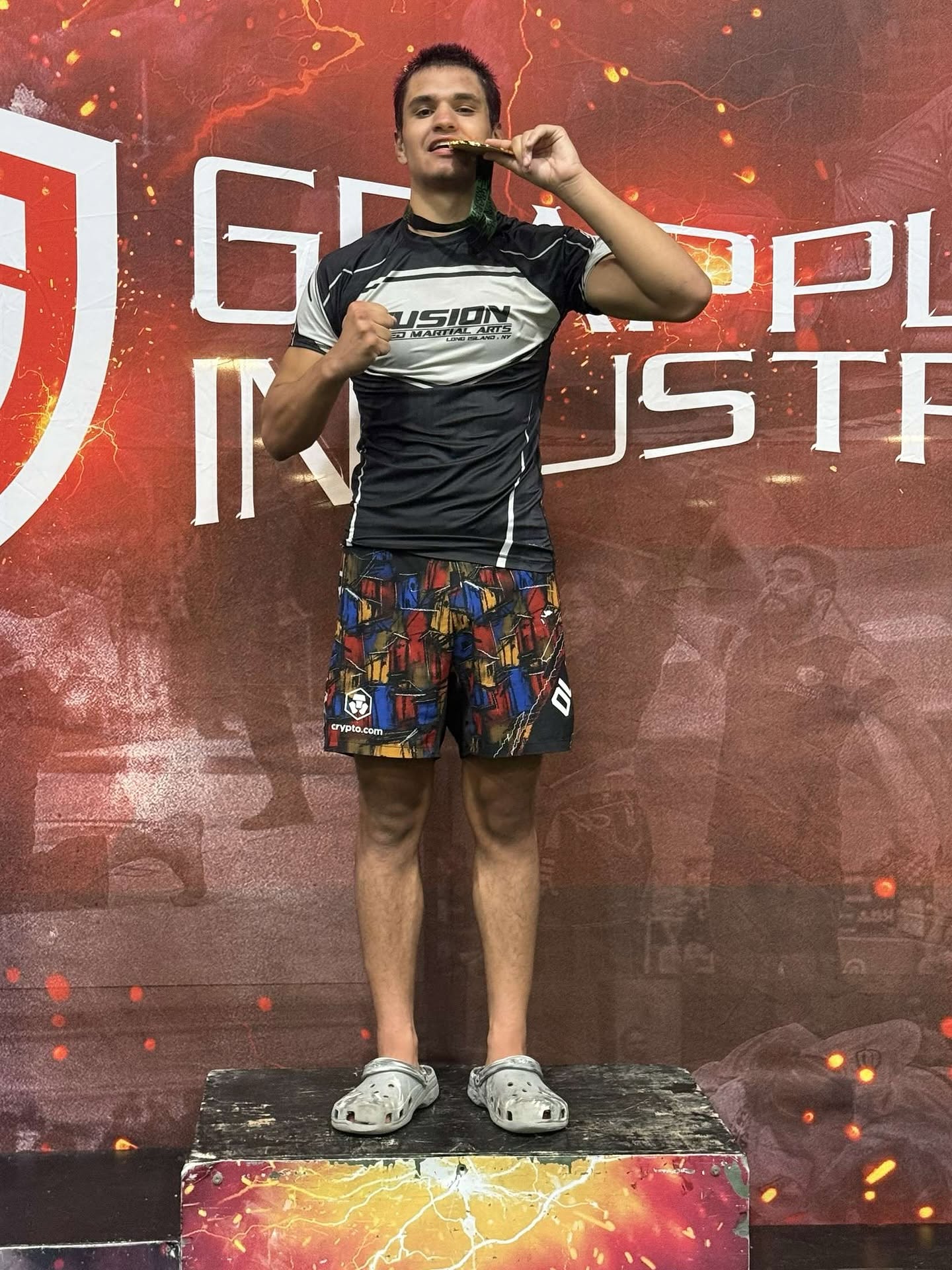 Fusion competitor with gold medal on Grappling Industries tournament podium