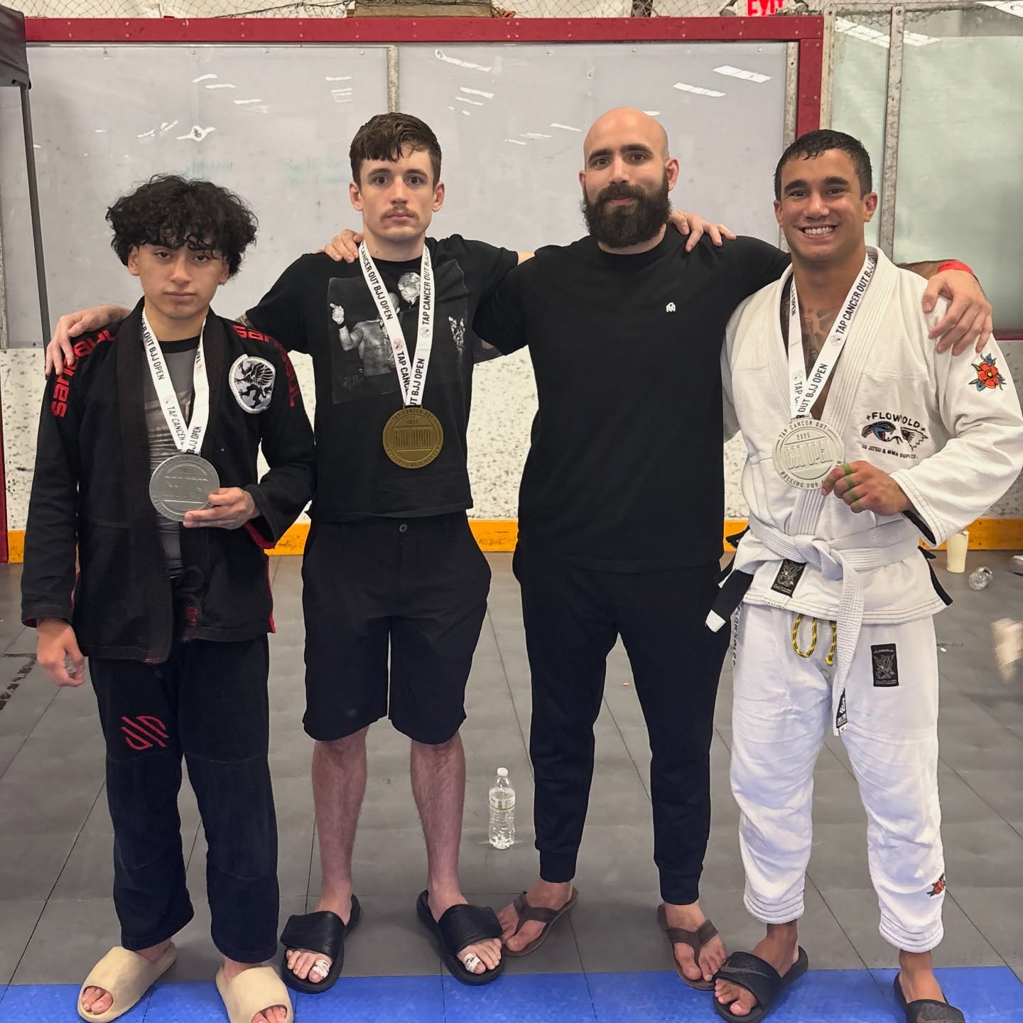 Fusion Jiu-Jitsu tournament competitors with medals and coach
