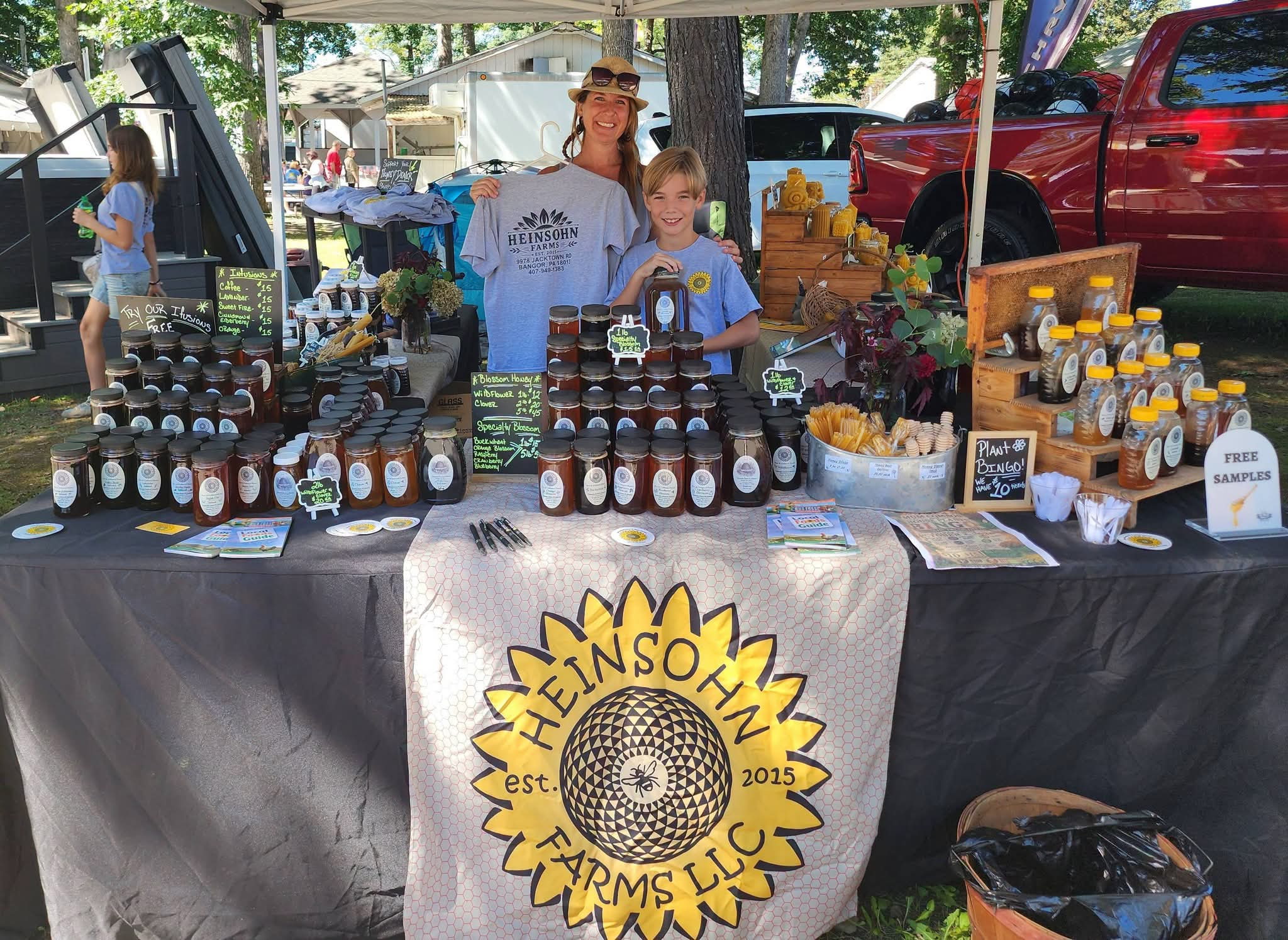 Heinsohn Farms family at a local community market booth with raw honey and farm products