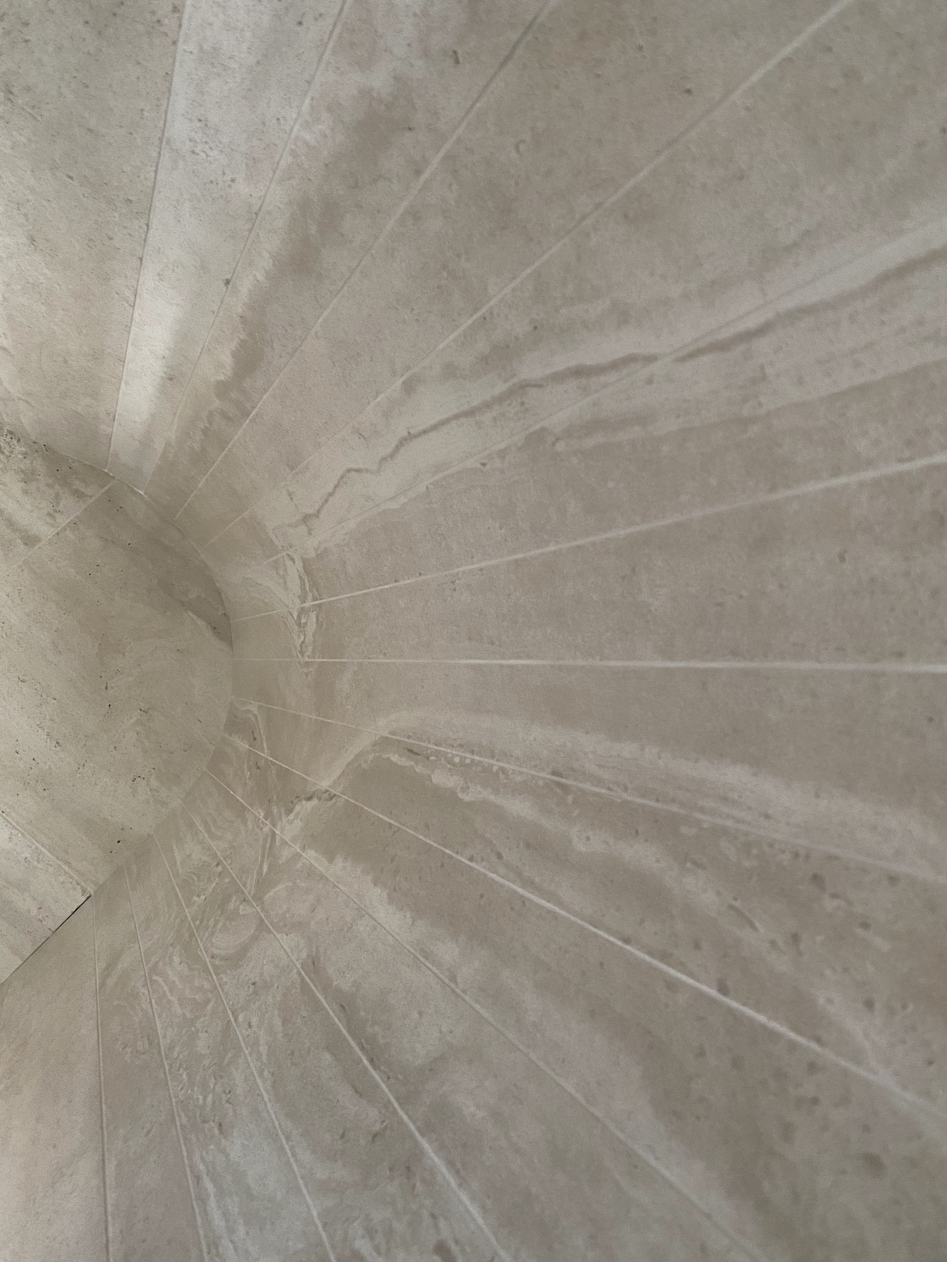 Curved radial stone feature ceiling and wall tile installation with precision alignment.