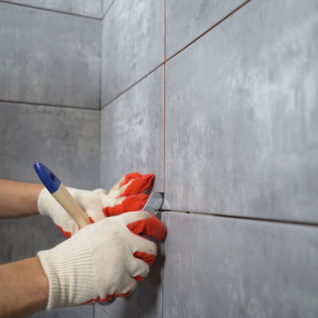 Specialist tile repair and grout line inspection on damaged wall tiles