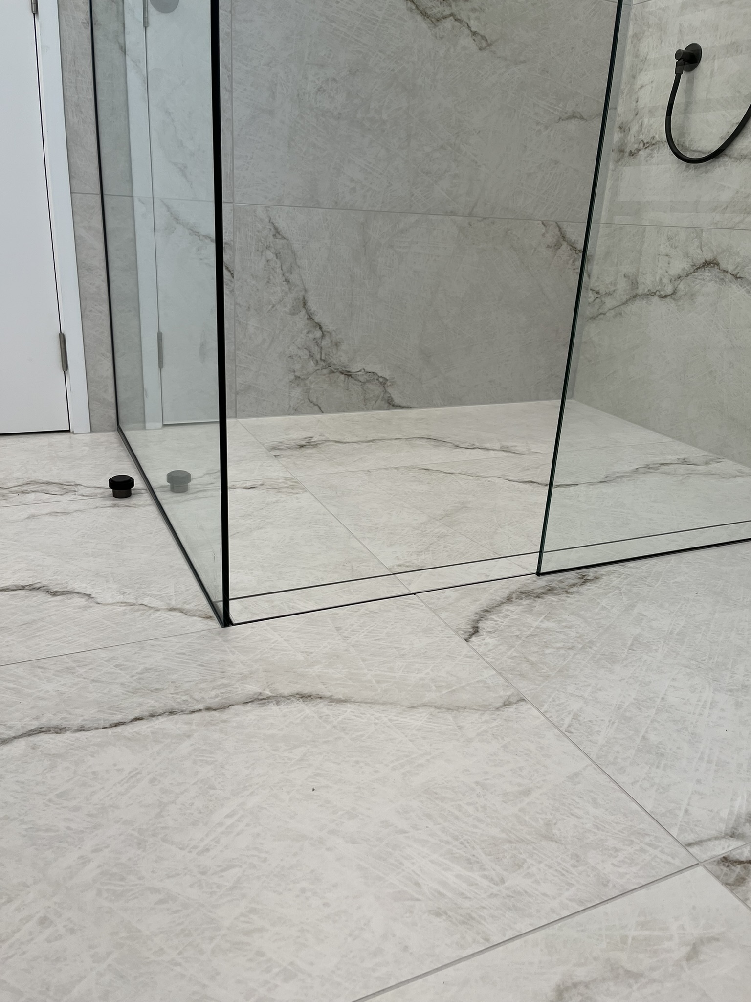 Precision walk-in shower tile and glass junction alignment