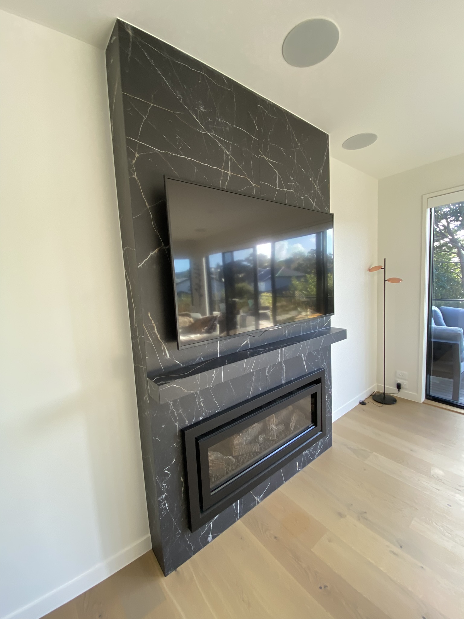 Black marble mitred fireplace surround and hearth feature tiling.