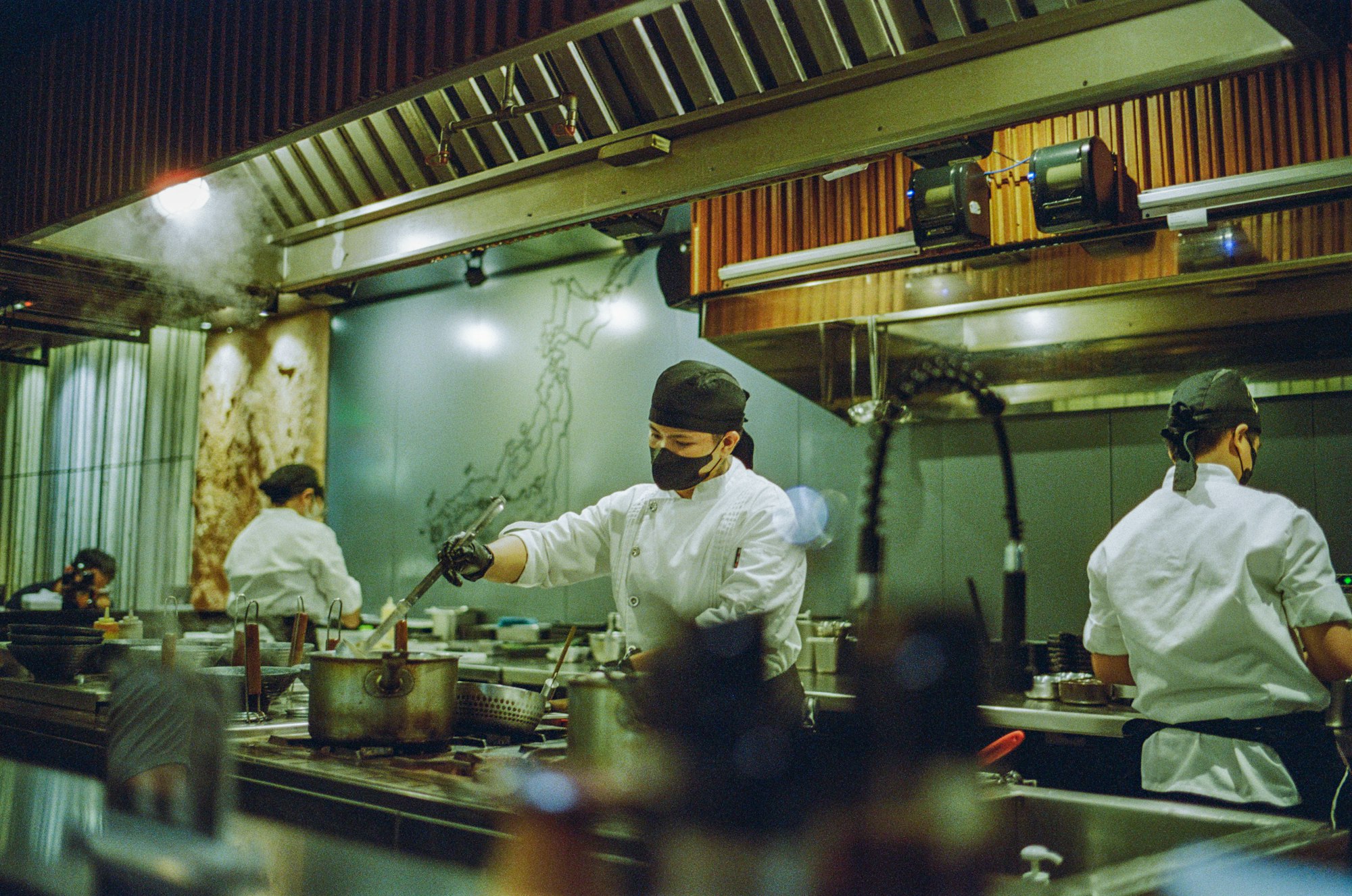 Chefs plating dishes on a restaurant kitchen line during service