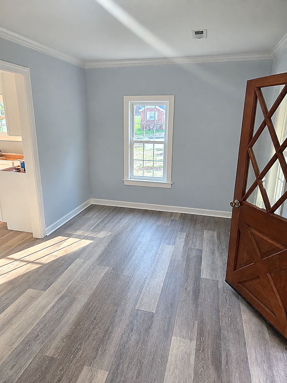 Finished room with new plank flooring, fresh paint and white trim after a flood damage renovation by Tucker Built Construction