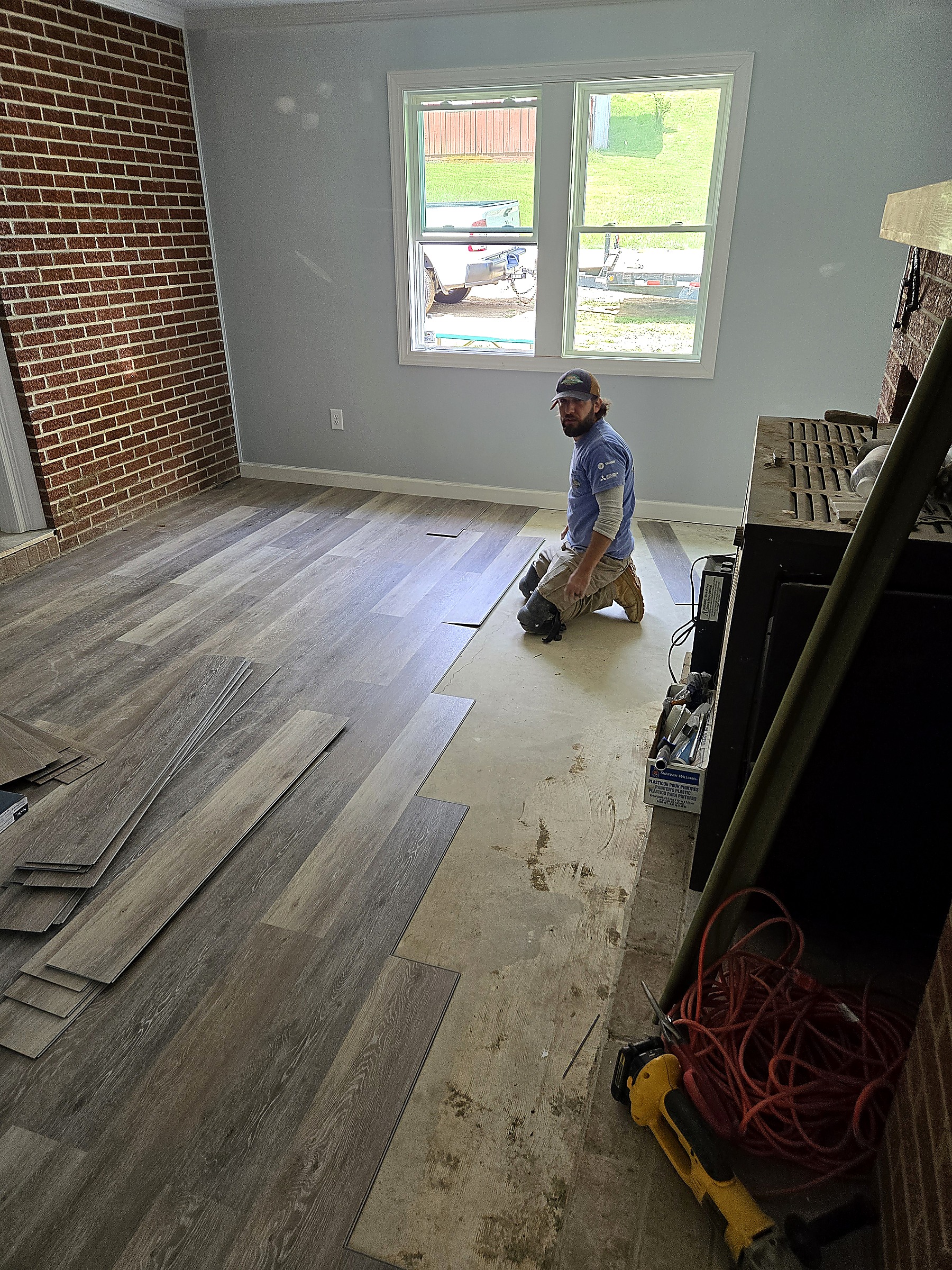 Tucker Built Construction crew member installing new plank flooring during a home renovation