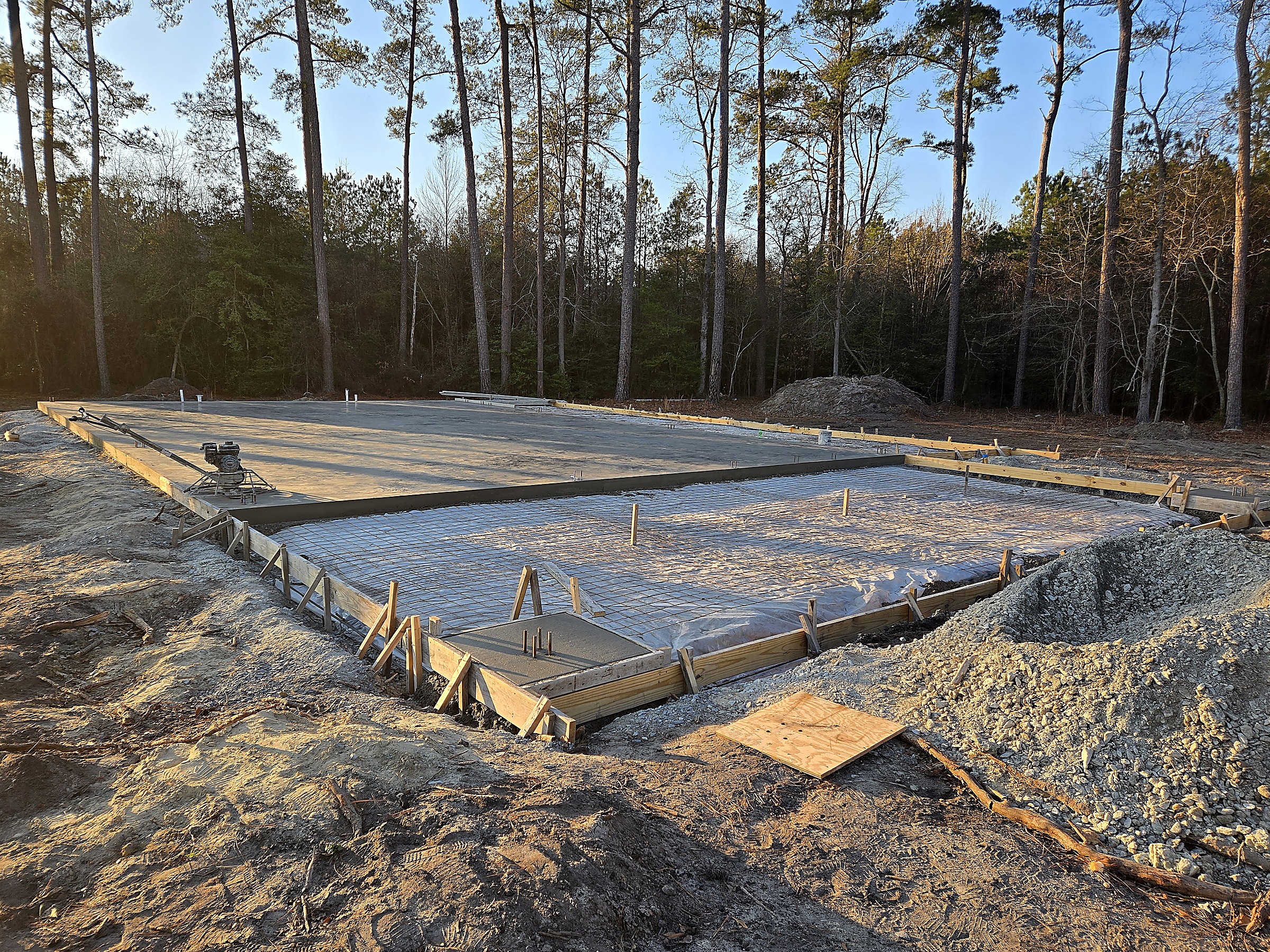 Graded building pad with concrete forms, wire mesh and gravel, prepared by Tucker Built Construction