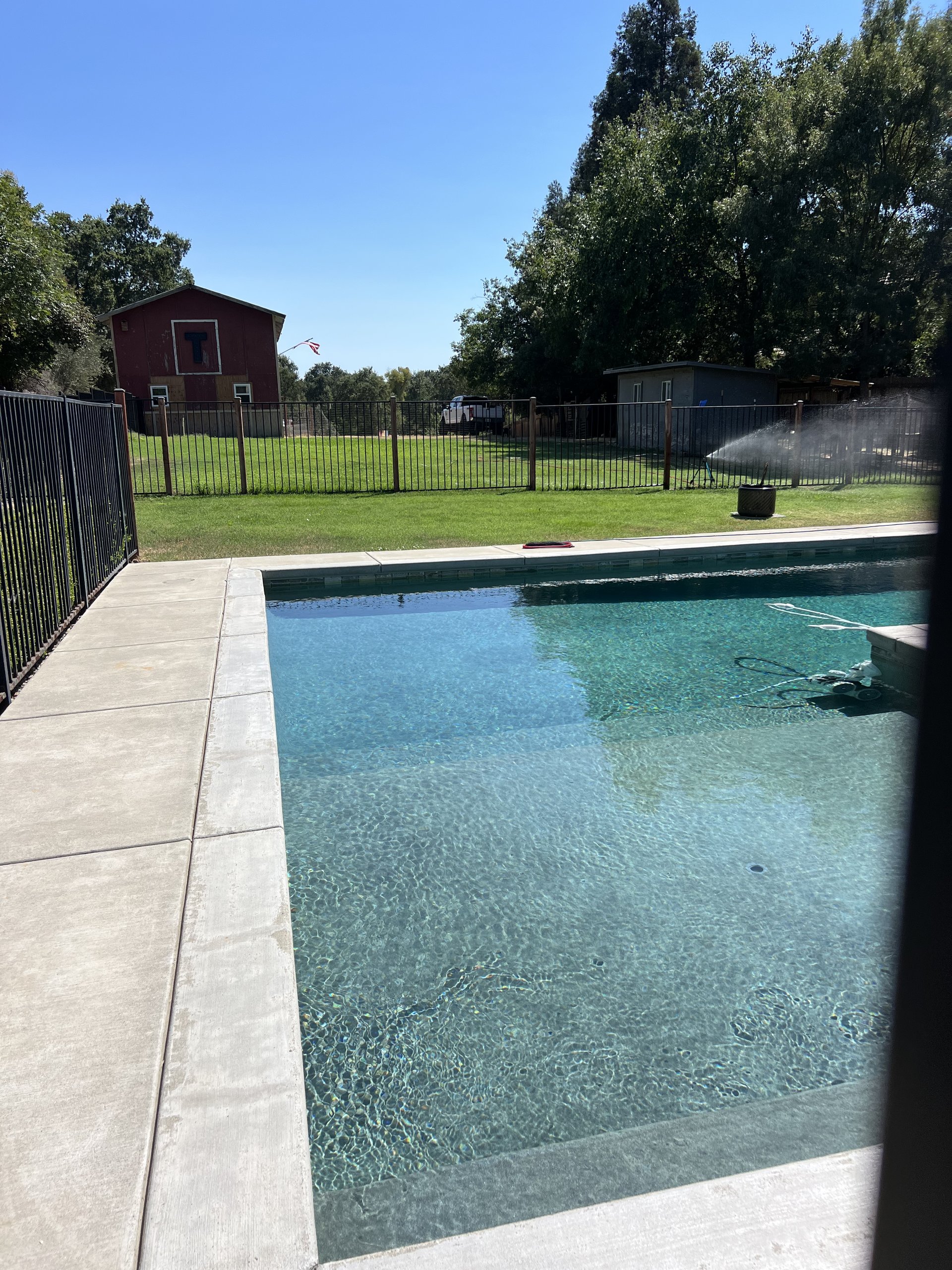 Pristine swimming pool and concrete patio with clear water