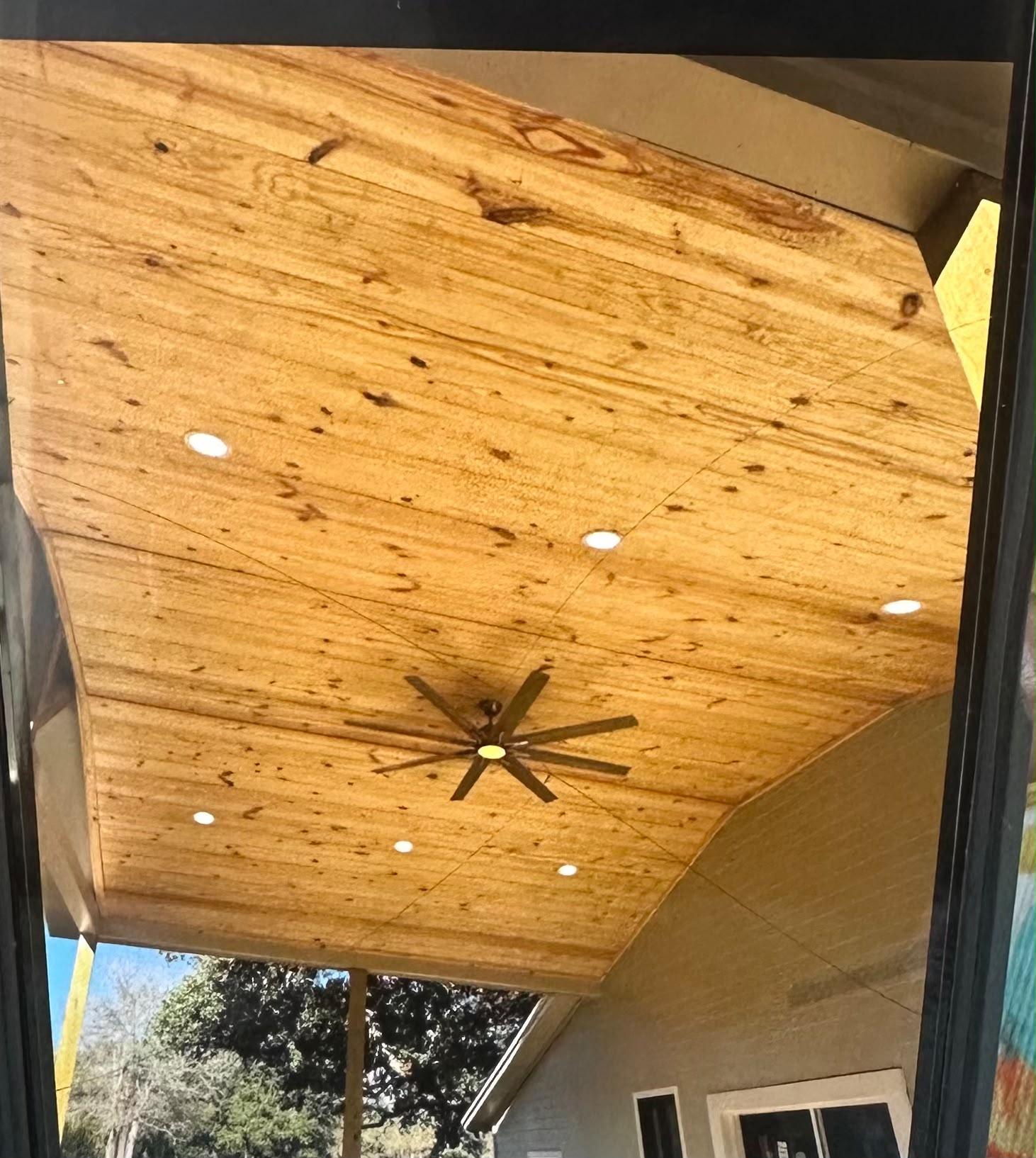 Covered patio wood ceiling with recessed can lighting and large outdoor ceiling fan by Anaeli GM Electric LLC