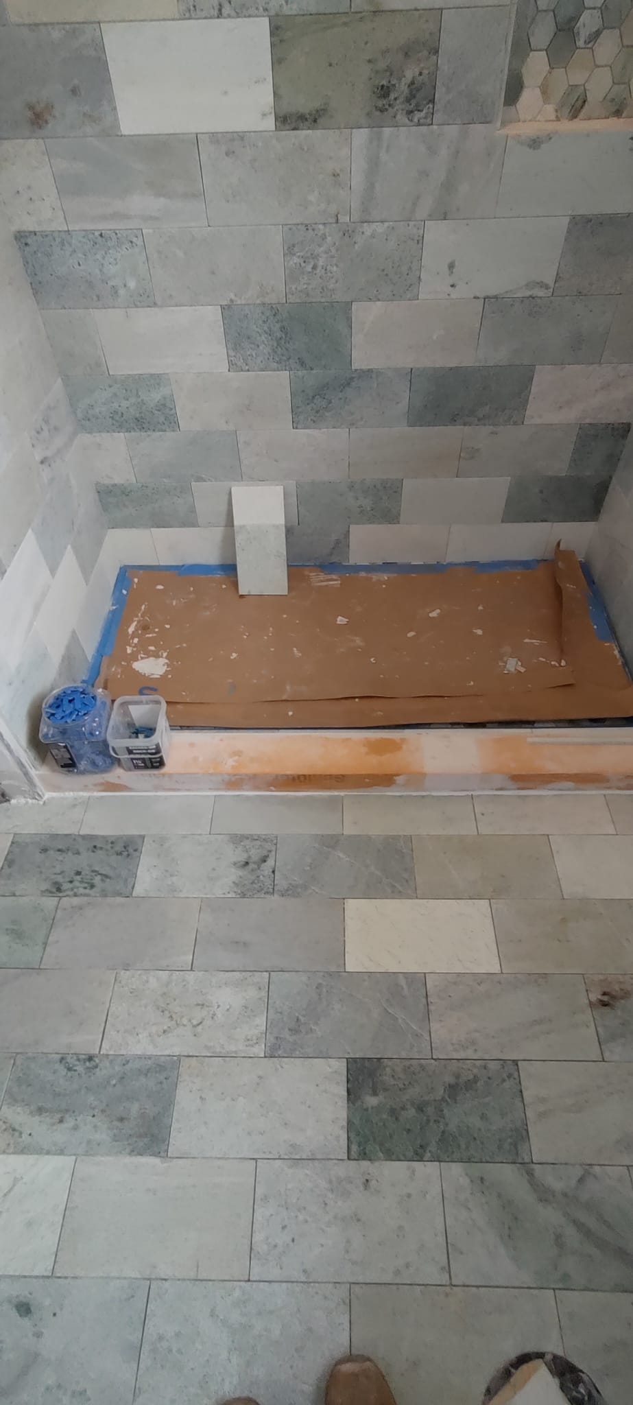Honed marble wall tile installation with waterproof curb and pan protective covering by Roberto Vicente in Greenville SC