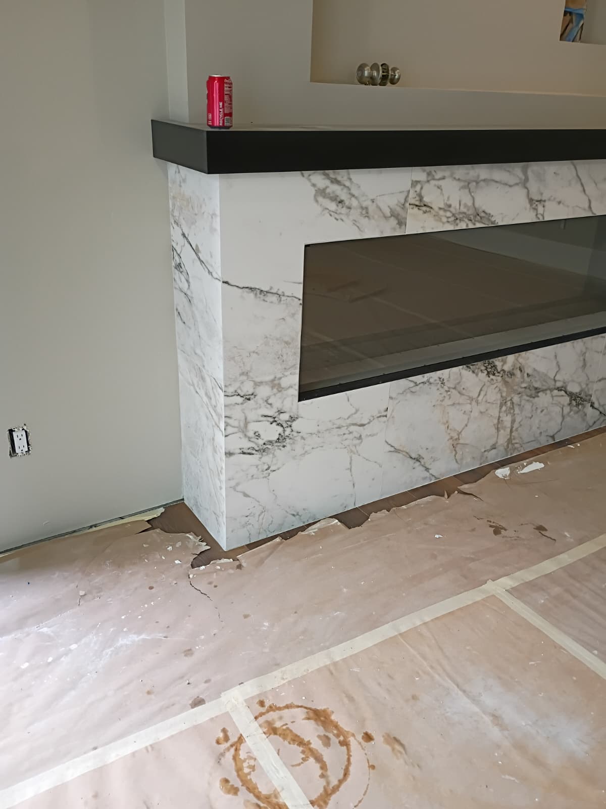 Side perspective of custom Calacatta marble porcelain fireplace surround with dark top mantle shelf and linear fireplace in Clemson SC