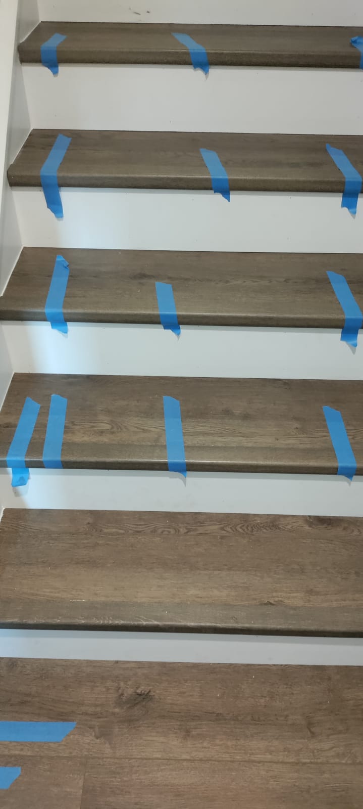 Custom luxury vinyl plank stair treads with crisp white risers installed by Rvicente Remodeling LLC in Easley SC