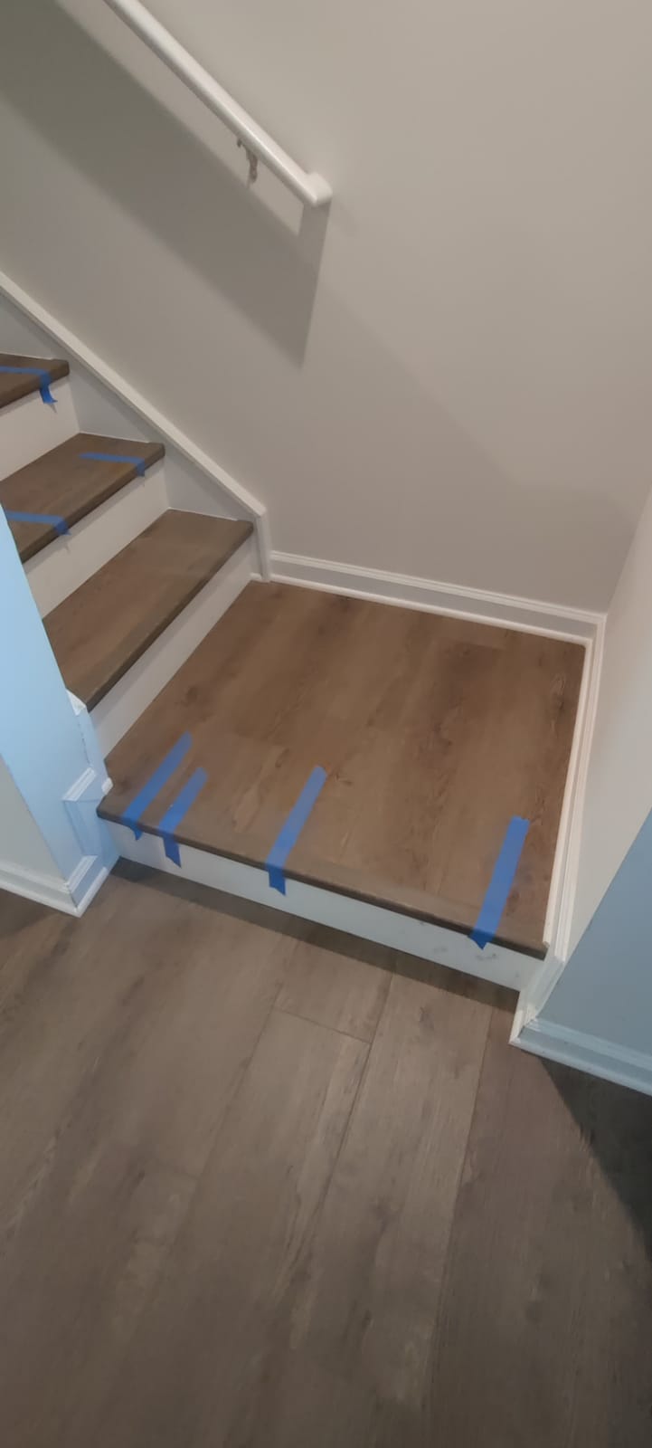 Luxury vinyl plank staircase landing and matching baseboard trim installation by Rvicente Remodeling LLC in Anderson SC