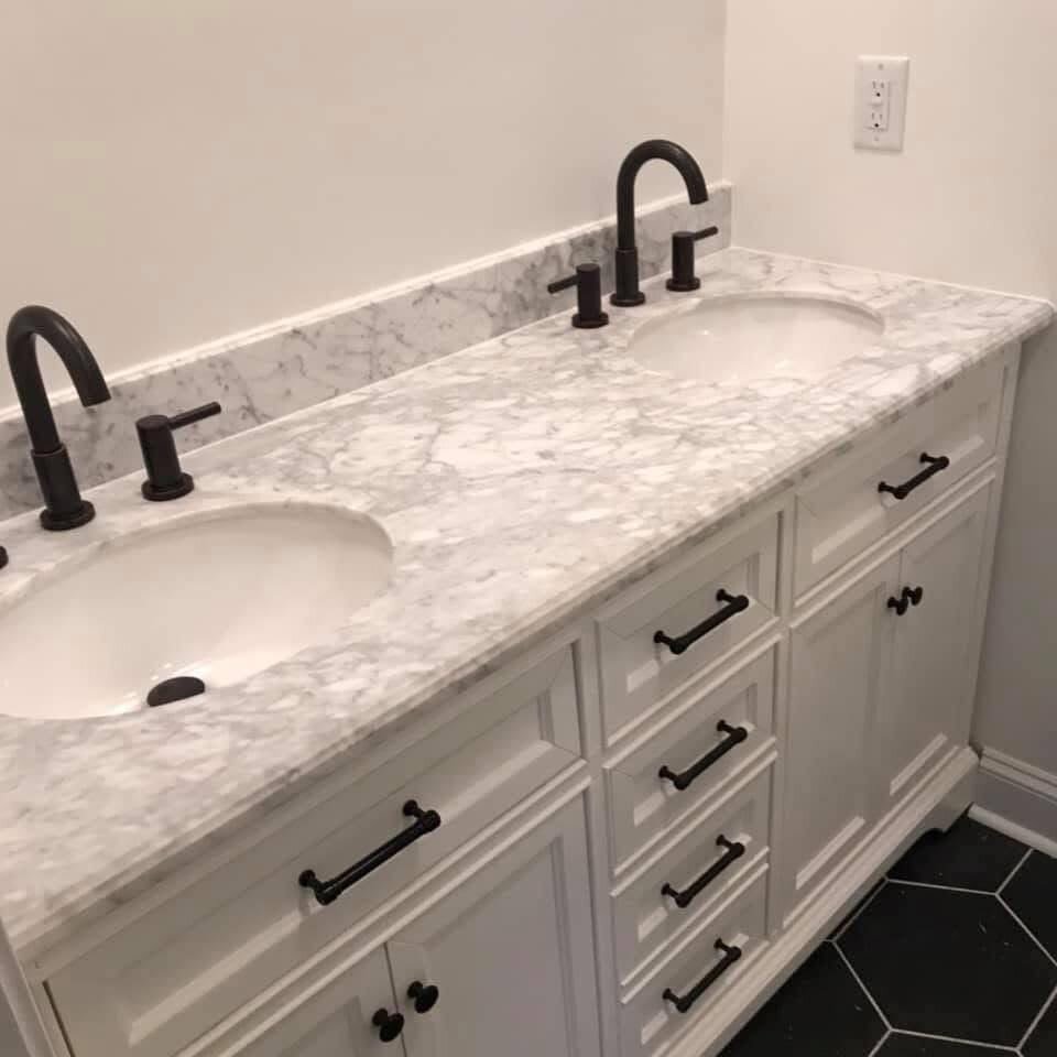 Mueble de baño doble con encimera de mármol y grifos negros instalados