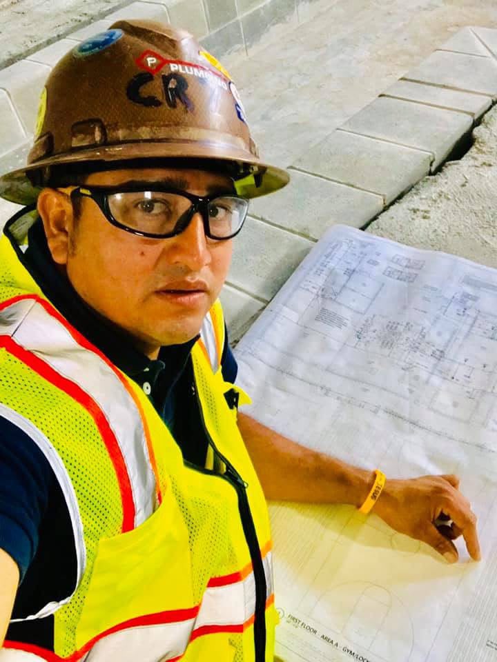 Gabo Ochoa en obra revisando planos de plomería