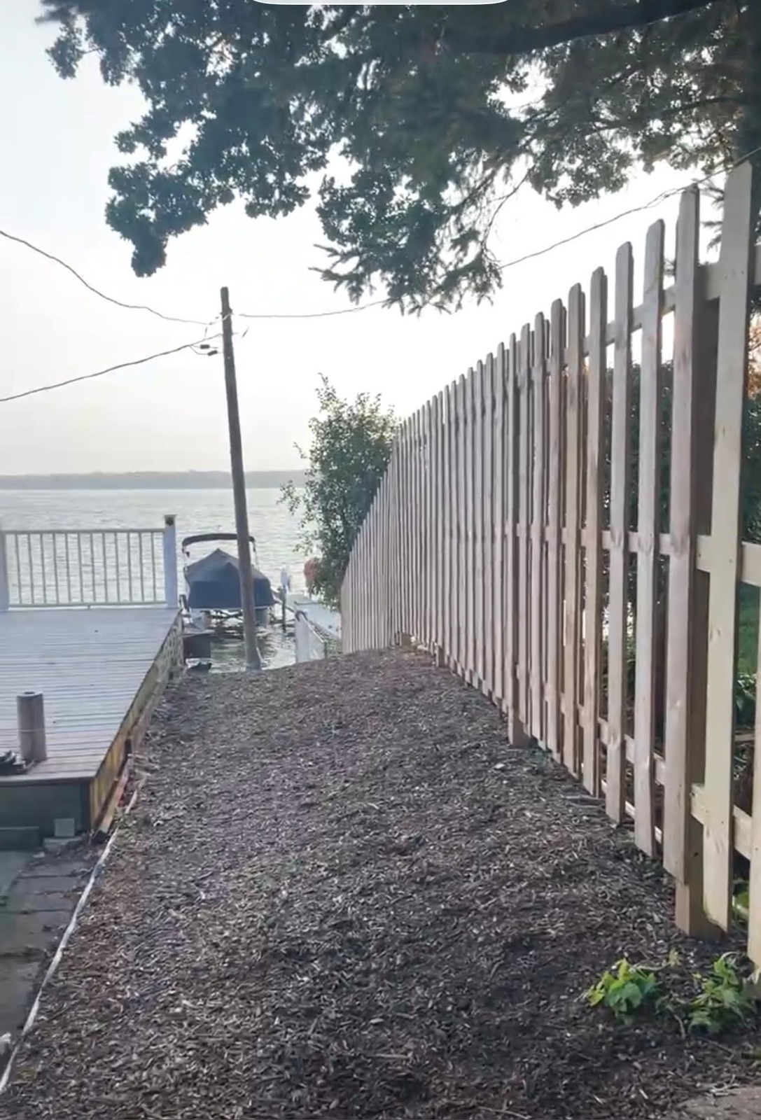 Long white fence running along a lake