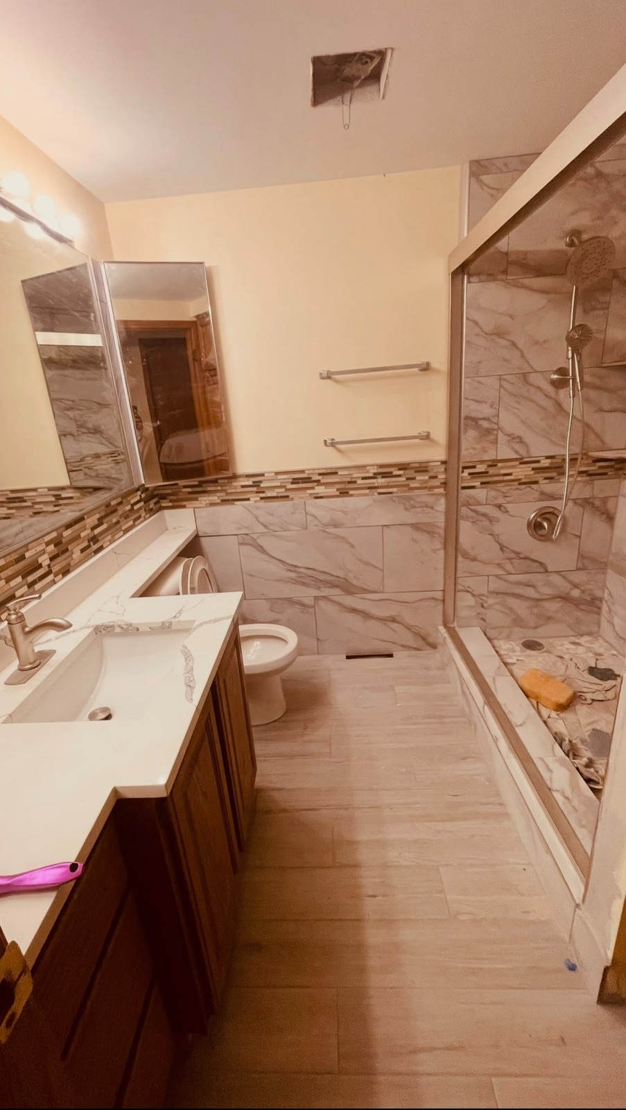 Remodeled bathroom with marble shower and glass enclosure