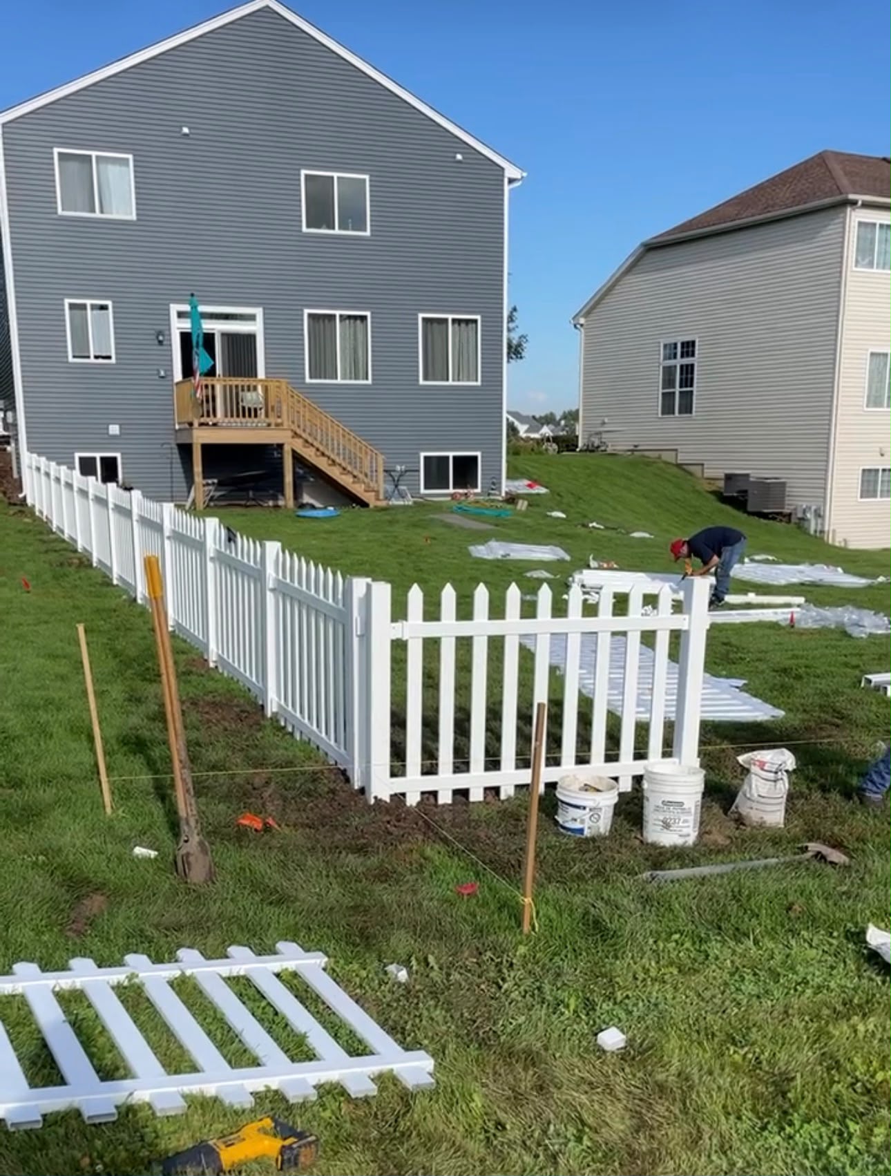 White vinyl picket fence installation in progress