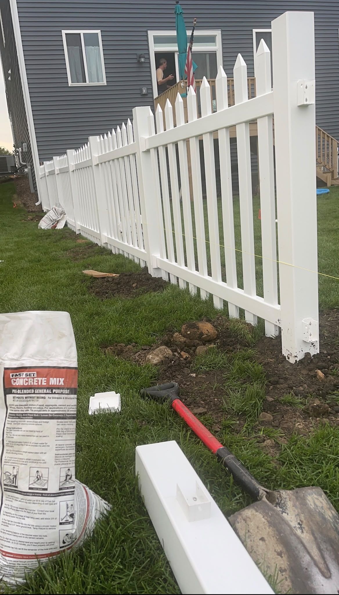 White vinyl fence posts and concrete setting