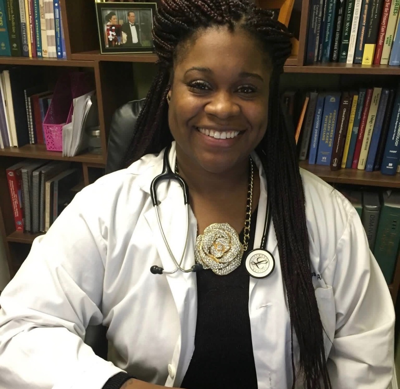 Tiana, Nurse & Community Connector wearing white medical coat with stethoscope