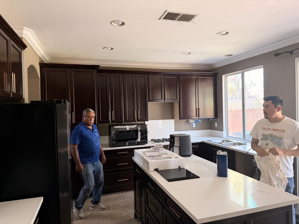 Master craftsman David Moncivais installing rich espresso kitchen cabinets and white quartz island in Chula Vista CA