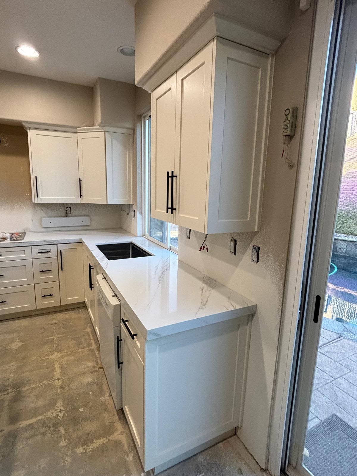 Pristine white shaker kitchen upper and lower cabinets with modern hardware by Custom Cabinets San Diego