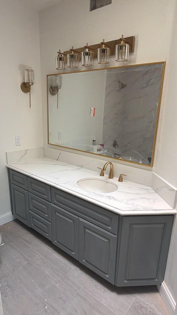Custom angled slate grey bathroom vanity with calacatta quartz top and gold fixtures in Coronado CA