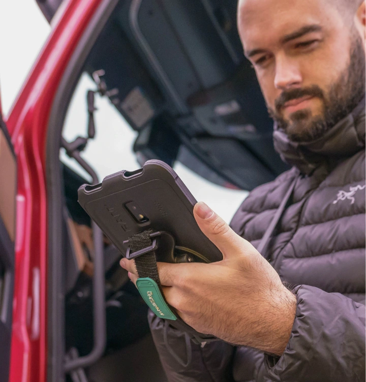 Conductor de logística y entrega utilizando tablet Samsung con correa de sujeción ergonómica
