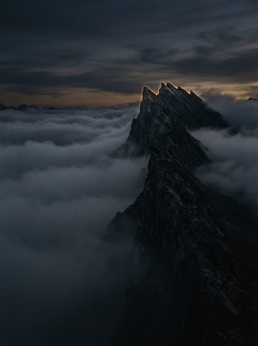Dark mountain ridge emerging from clouds