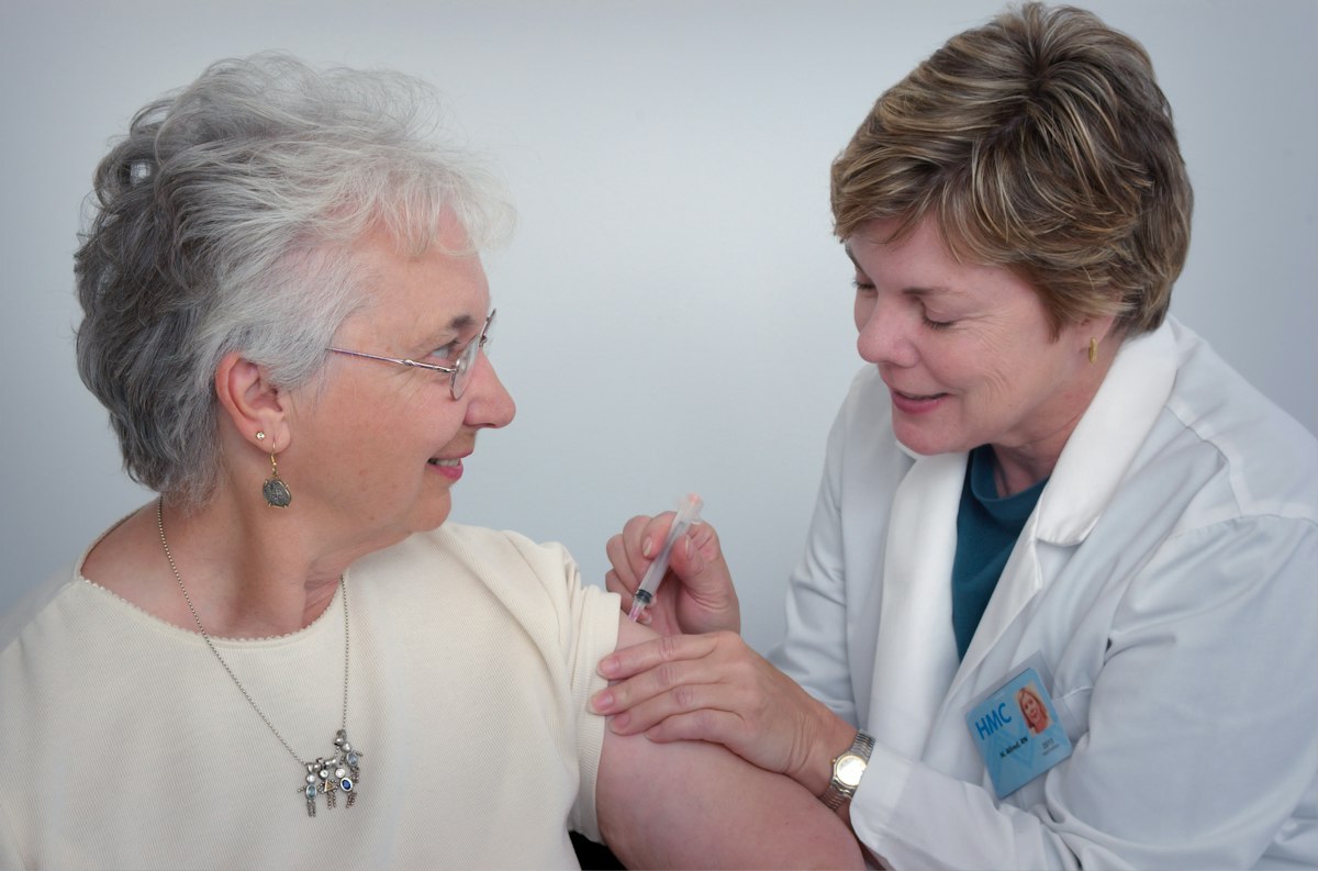An authentic, compassionate caregiver gently assisting an older adult woman at home in San Antonio