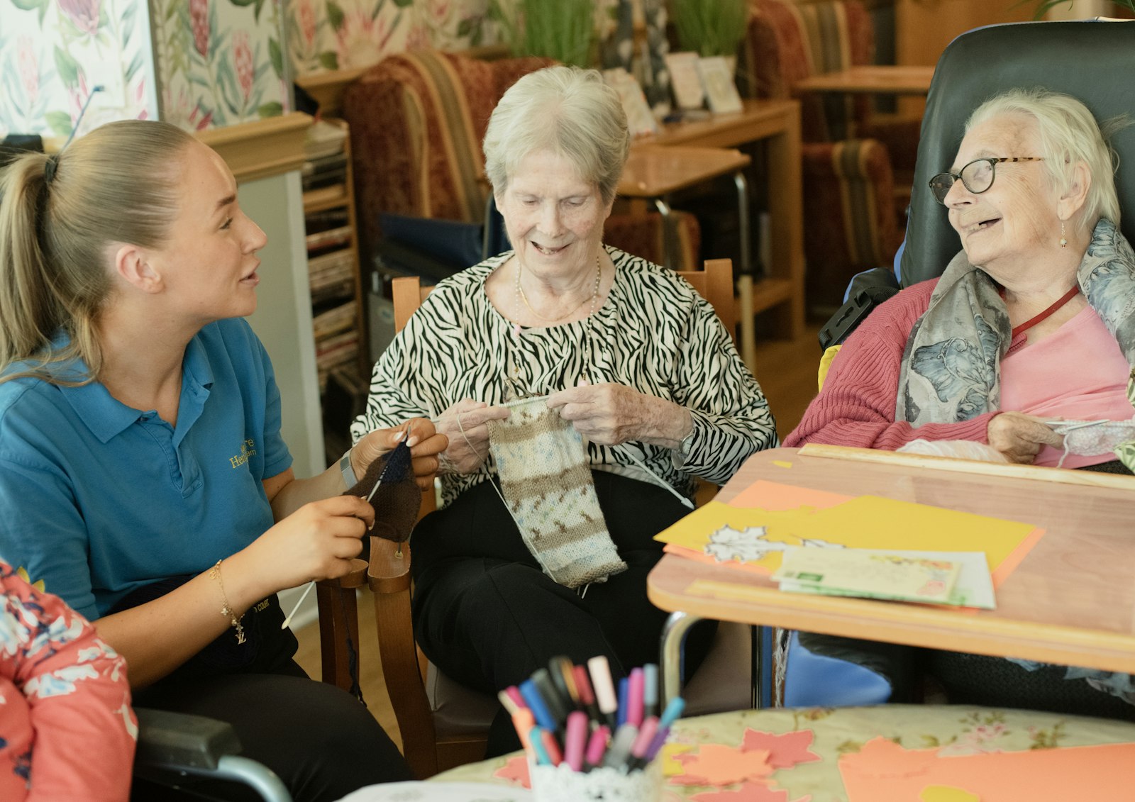 A caregiver warmly assisting an older adult woman with daily activities at home