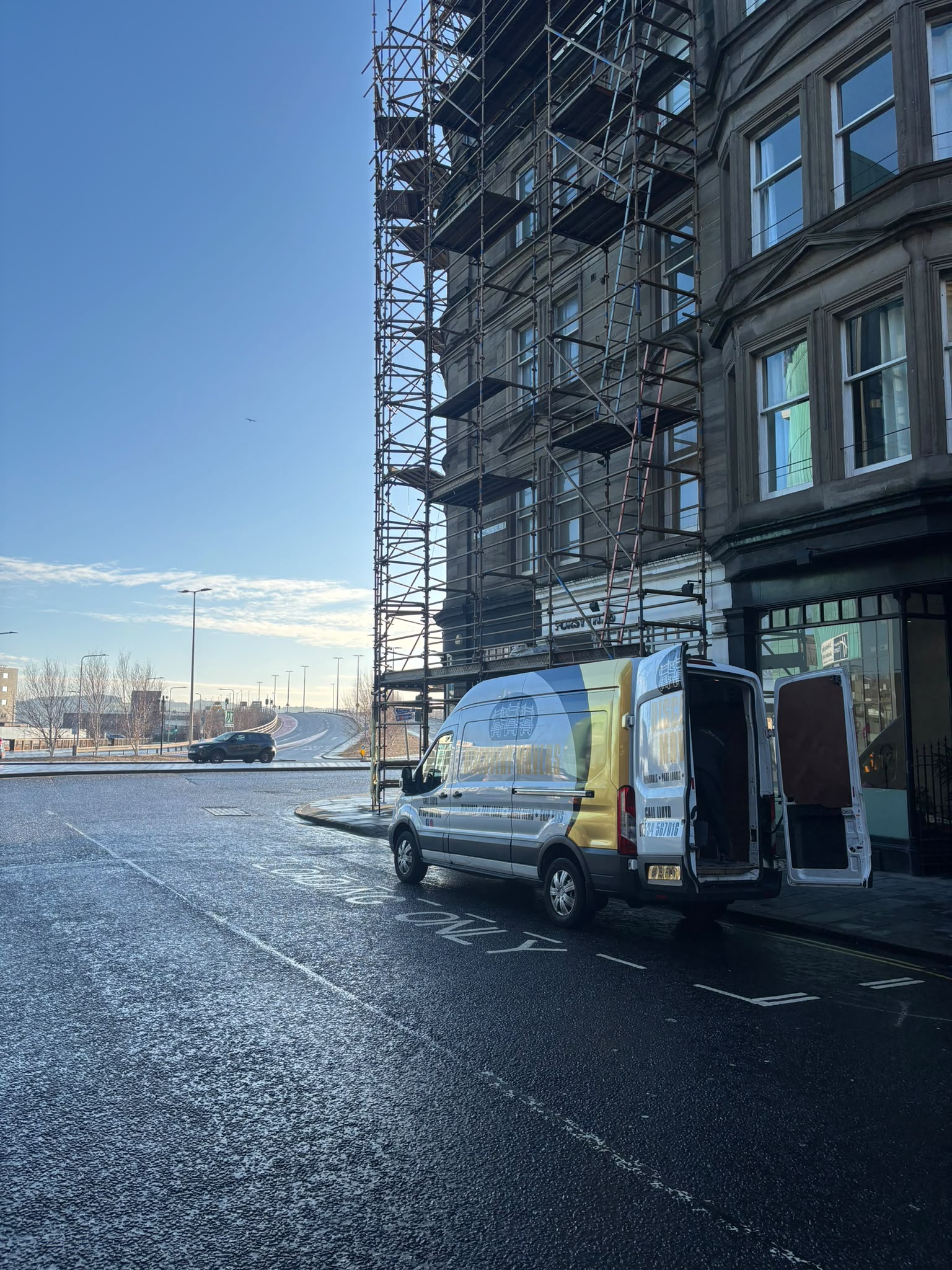 Discovery Movers removal van parked outside a traditional Dundee stone tenement and central street