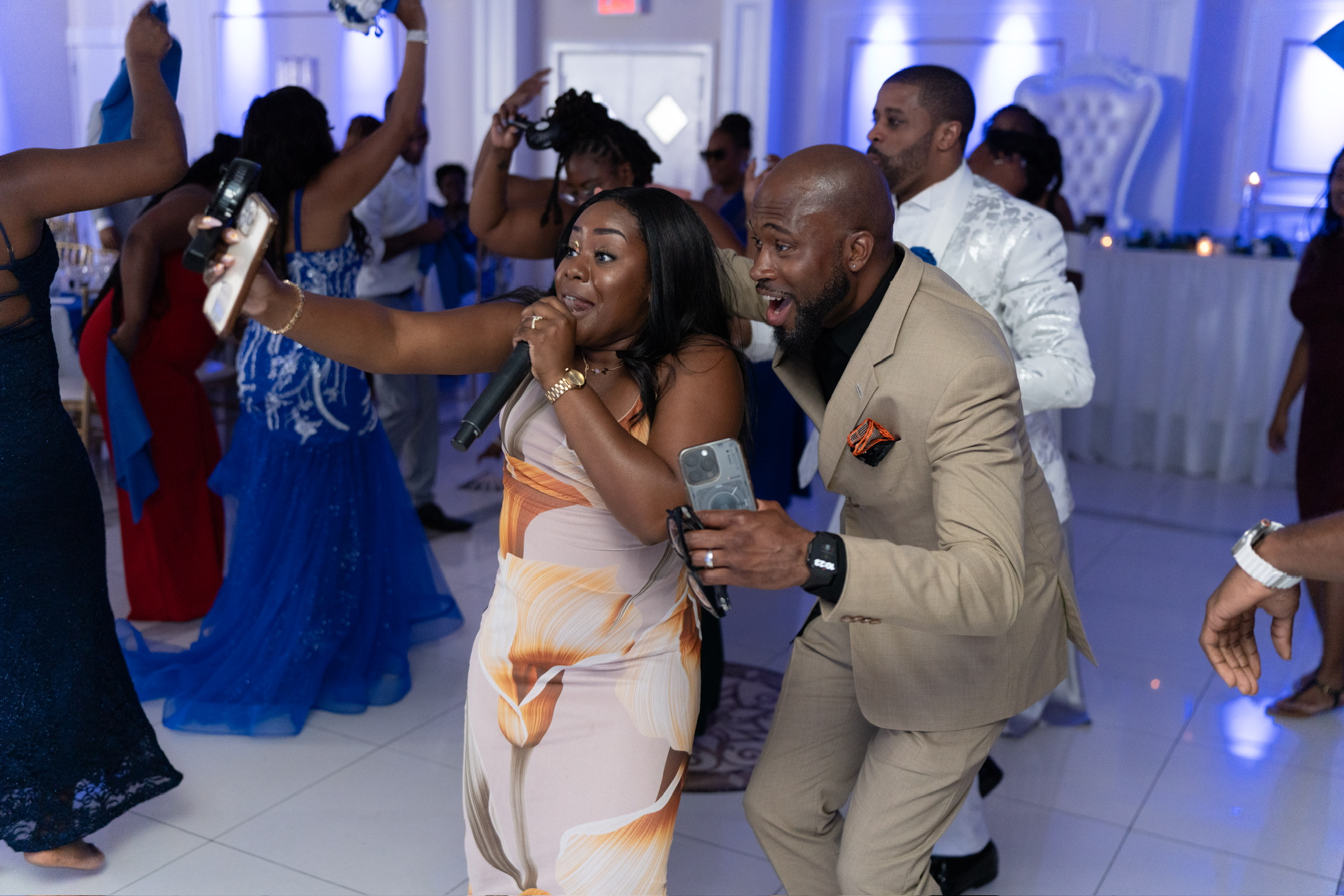Taje hyping up guests and singing on the dance floor with selfie crowd