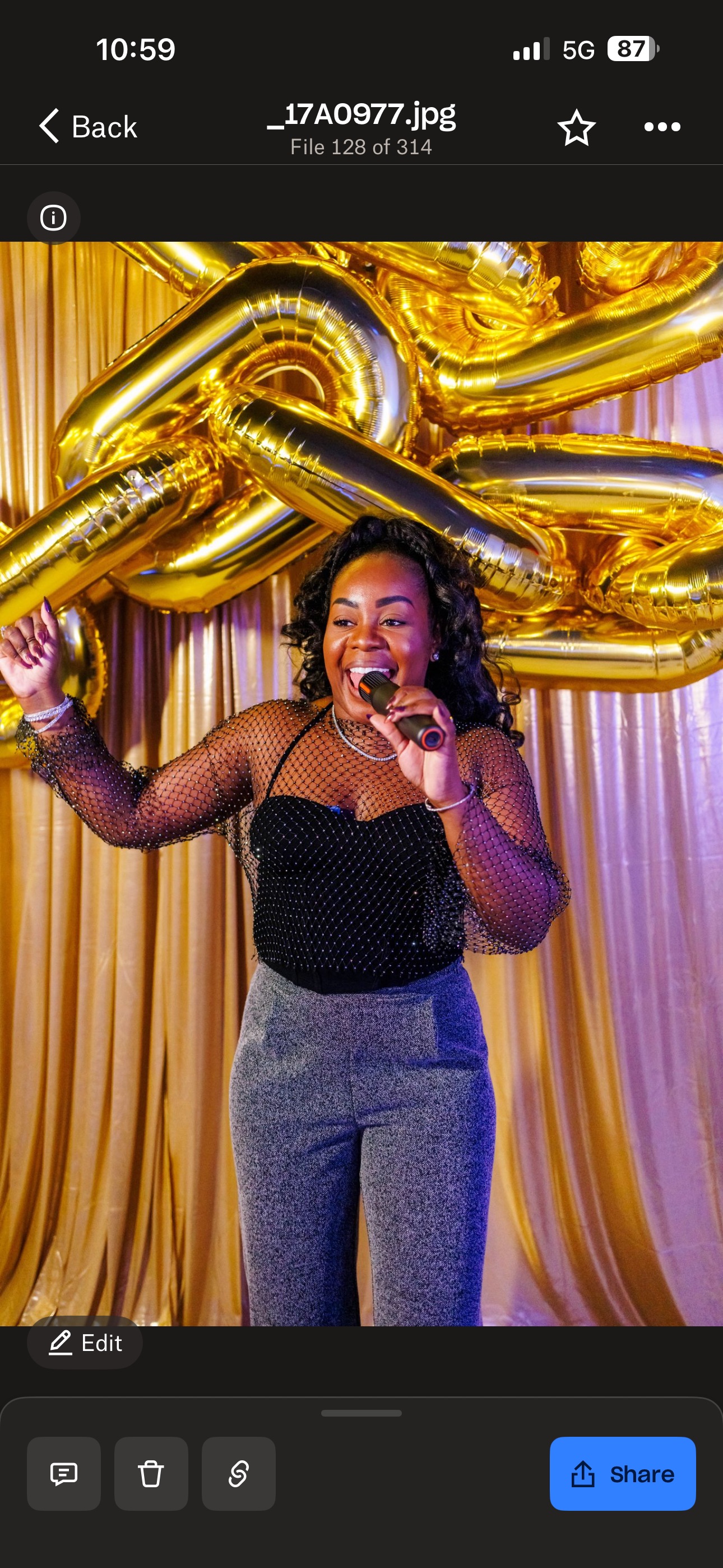 Taje MC hosting in front of gold backdrop with microphone