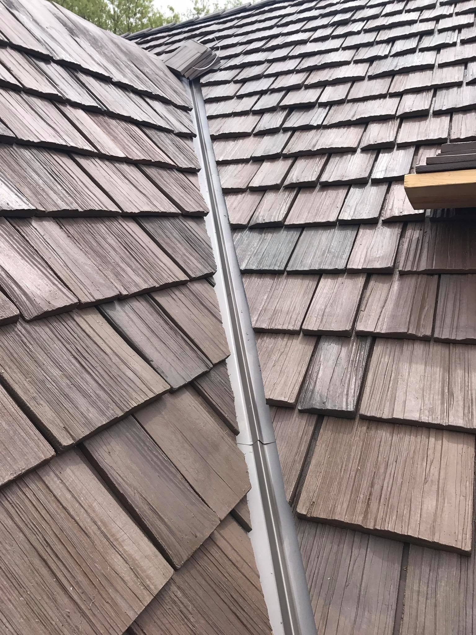 Close-up of composite shake roofing with custom metal valley flashing installation