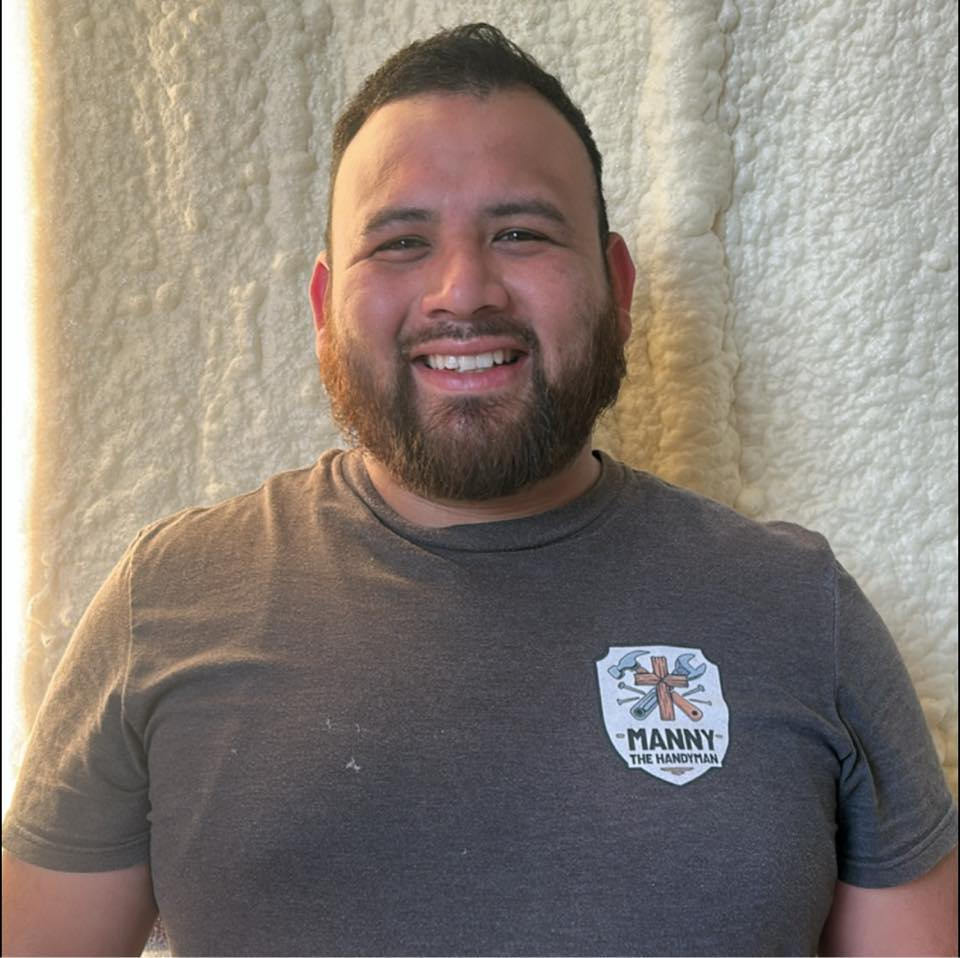 Manny, owner of Manny's Handyman Service smiling in branded uniform shirt
