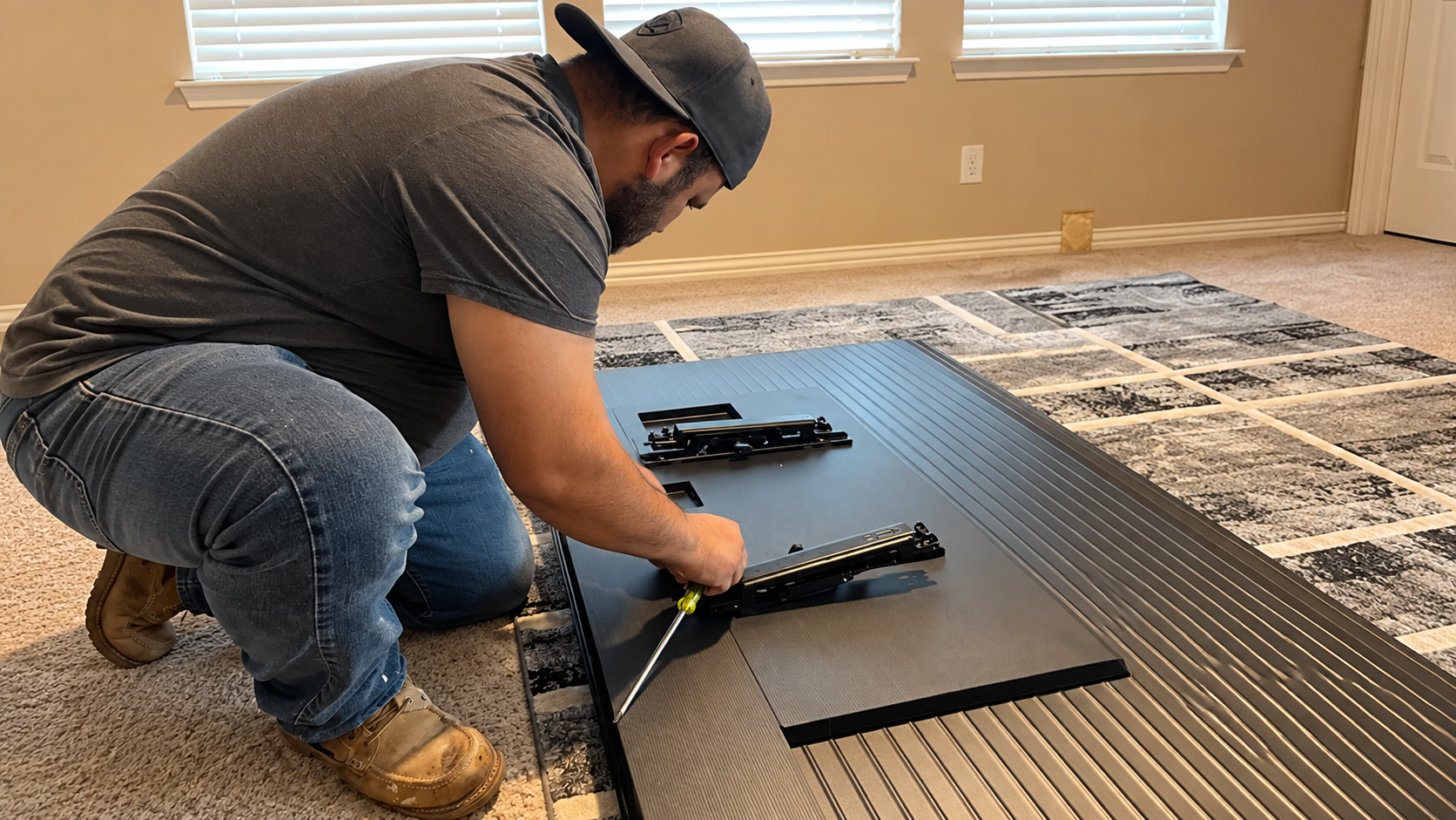 Manny installing TV mounting brackets on-site for a local customer