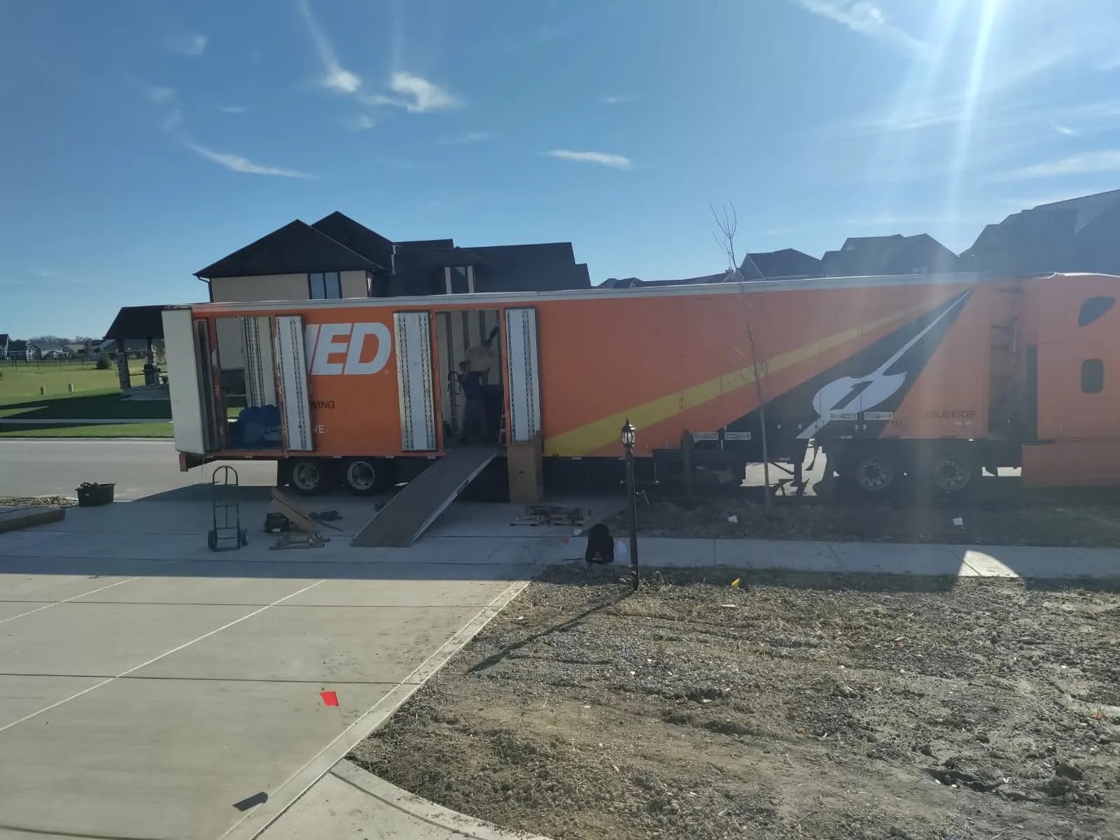 Commercial moving van with walkboard ramp loading furniture in Illinois