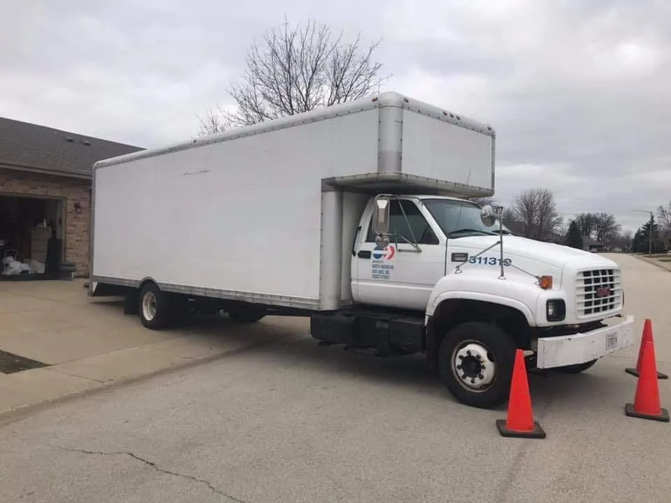 Cisco's Moving commercial GMC box truck staged with safety cones on a suburban street