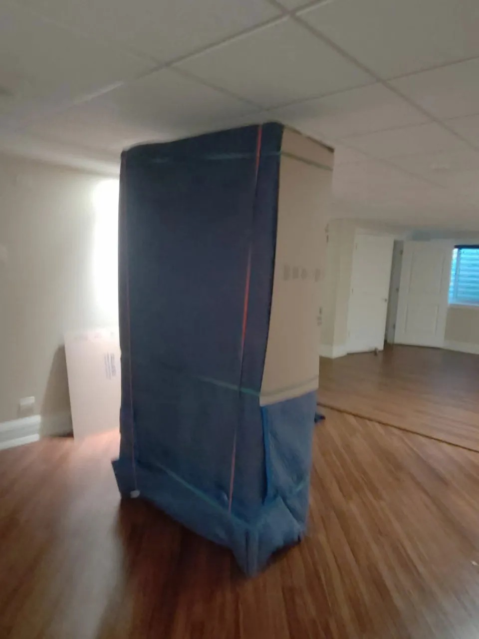 Wooden cabinet padded with moving blankets and shrink wrap in Plainfield