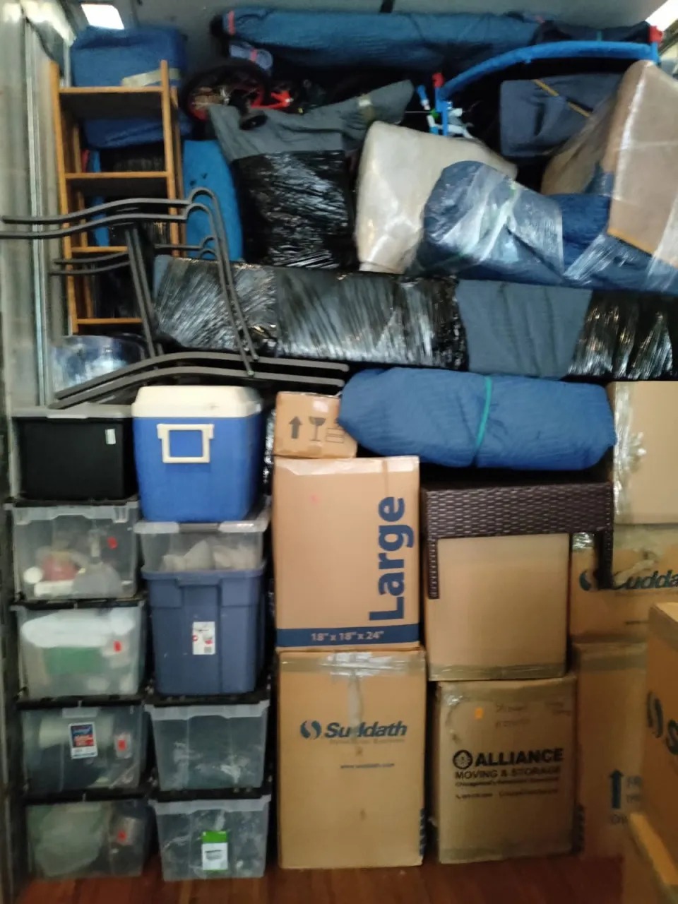 Mover stacking and strapping furniture tightly inside the moving truck in Naperville