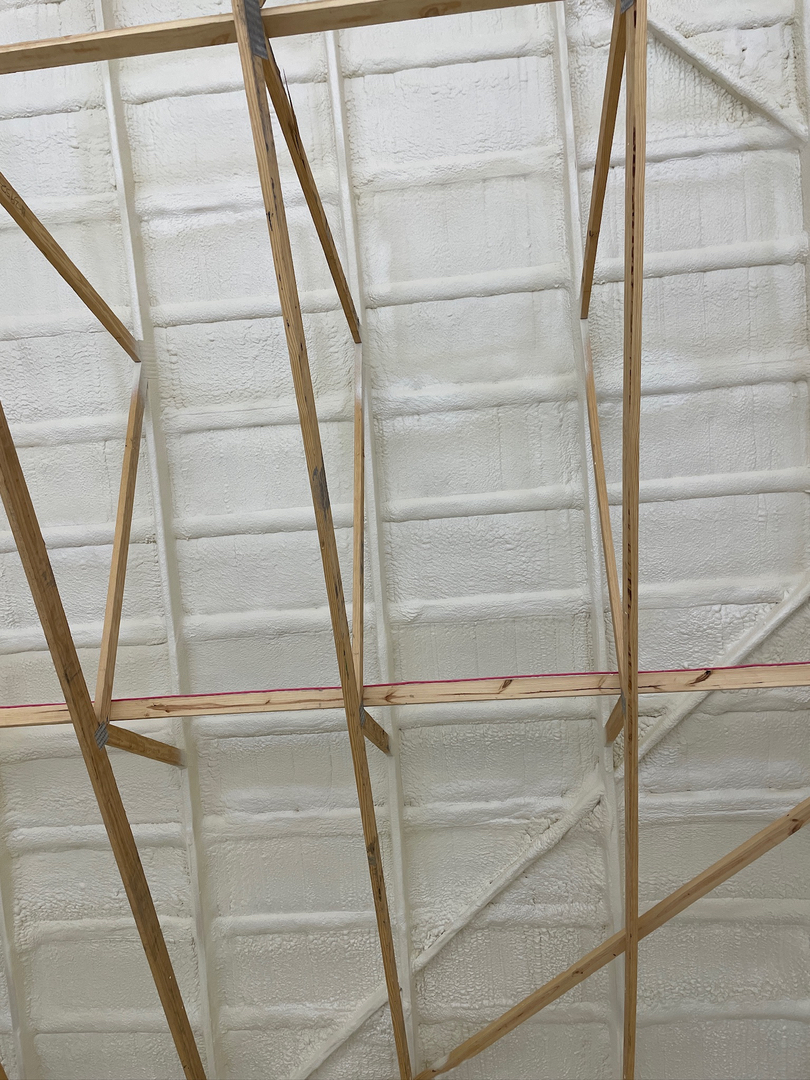 Spray foam insulation applied to post-frame roof trusses and girts in shop or barndominium structure