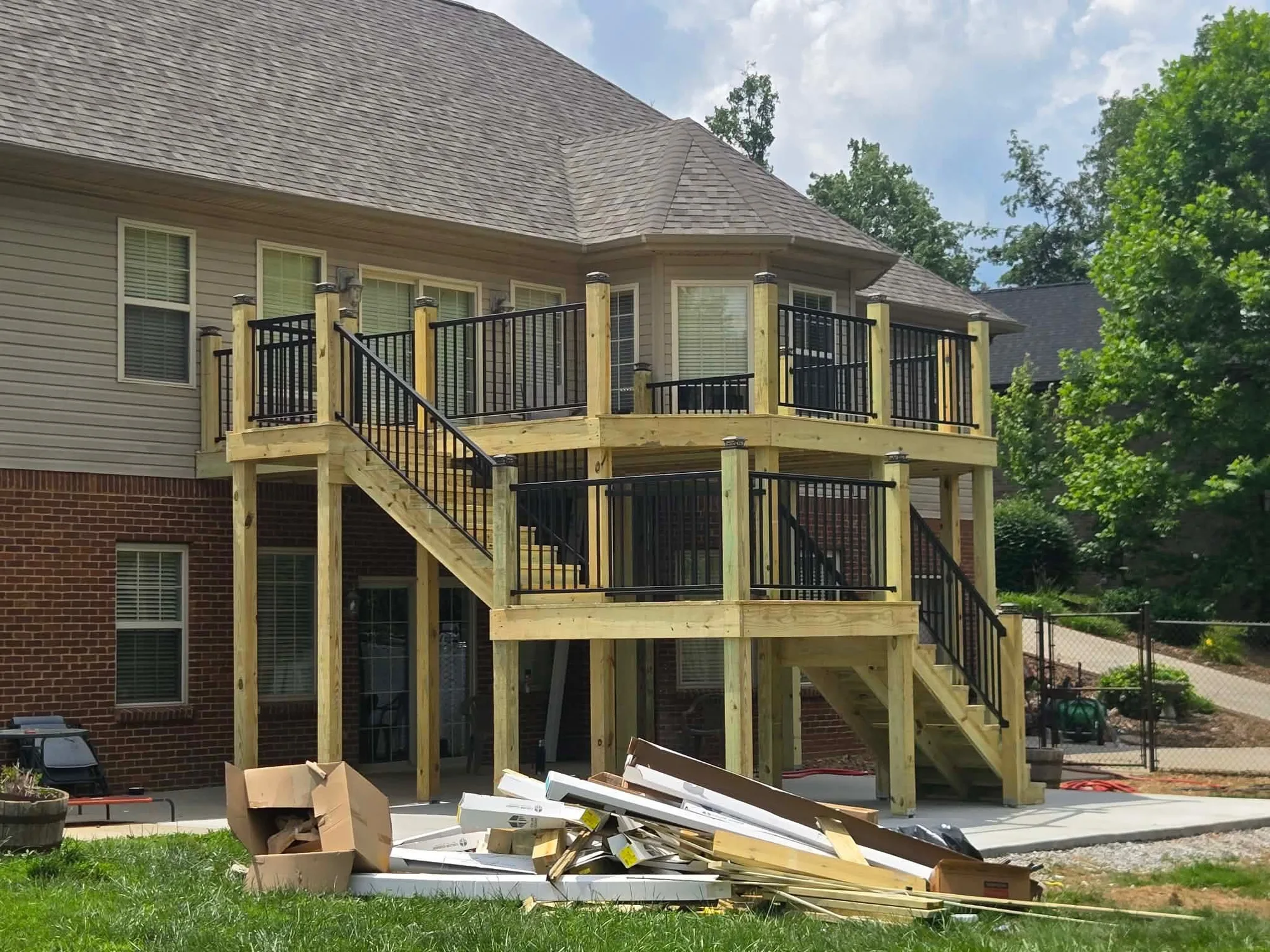 H&H Home & Bath Renovations multi-level pressure-treated elevated wood deck with black metal spindle railings and custom staircase