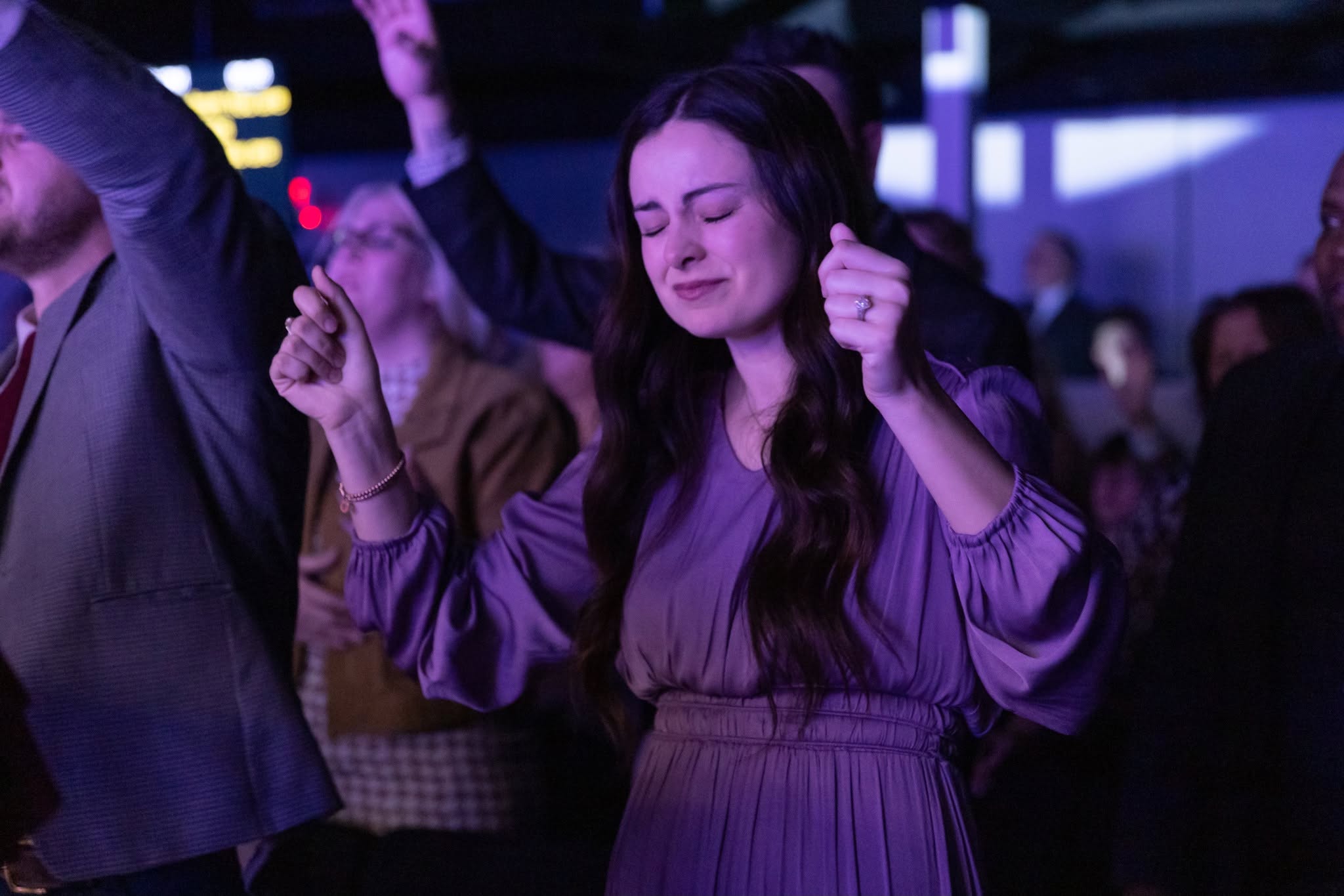 Young woman in deep worship in the congregation