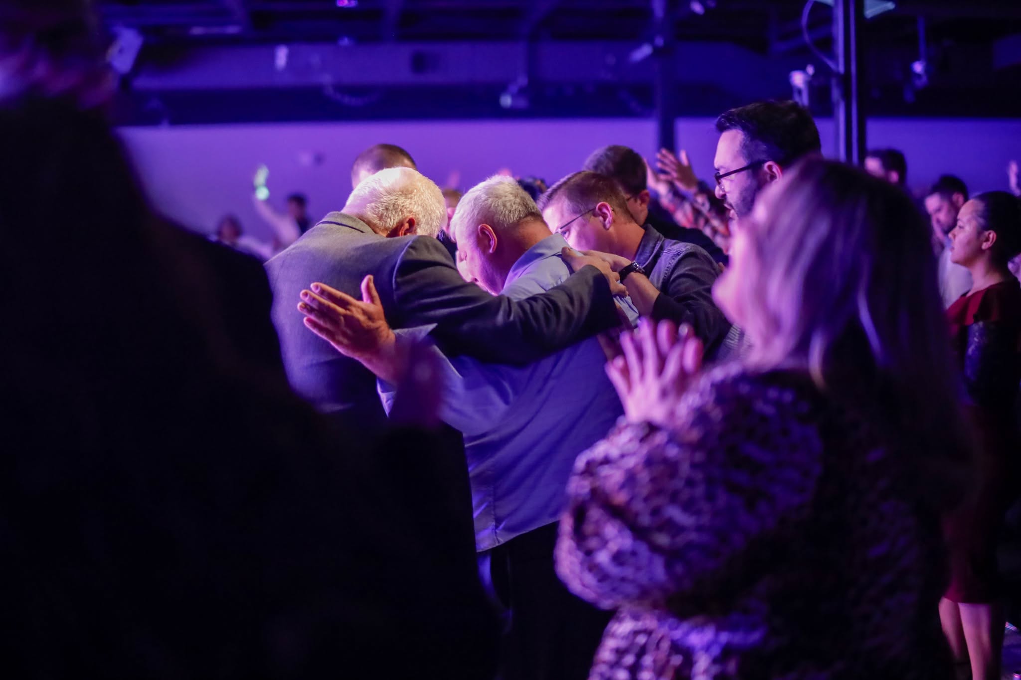 Ministers and congregation praying together at the altar