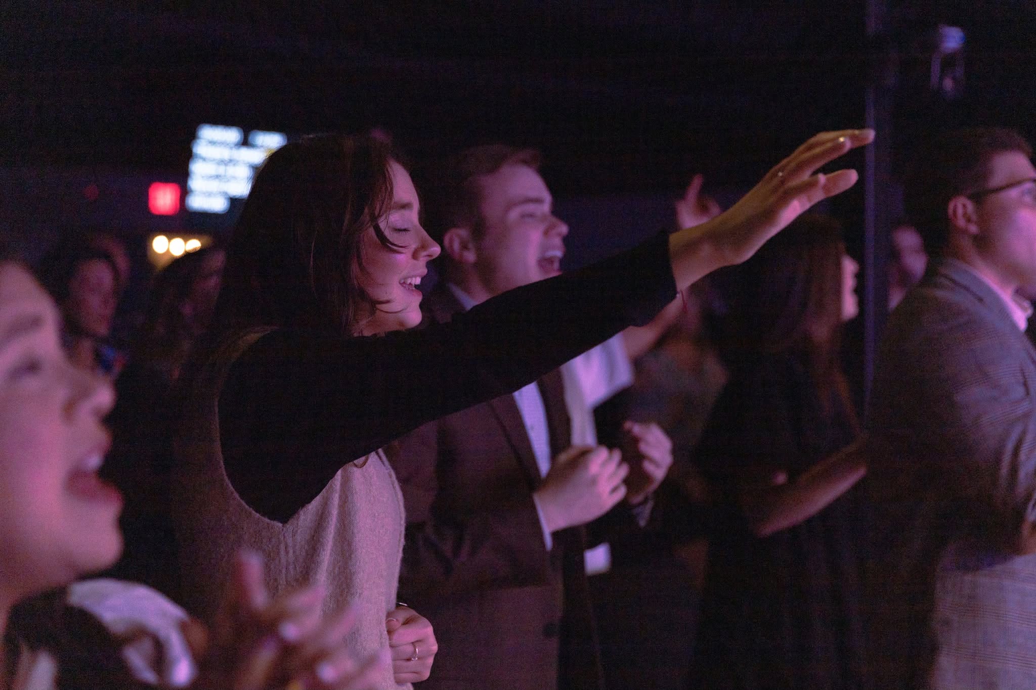 Young believers praising and worshiping with hands lifted