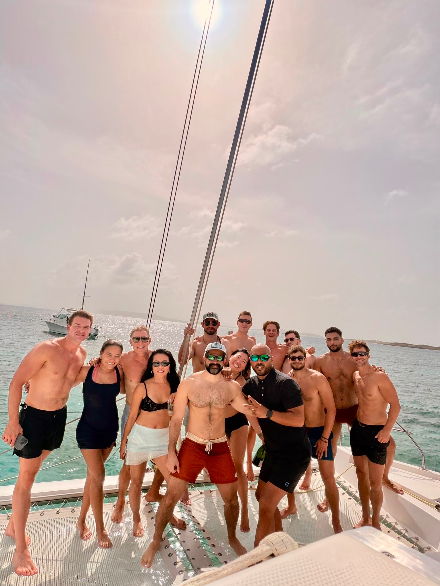 Large group of guests together on the forward deck of the catamaran